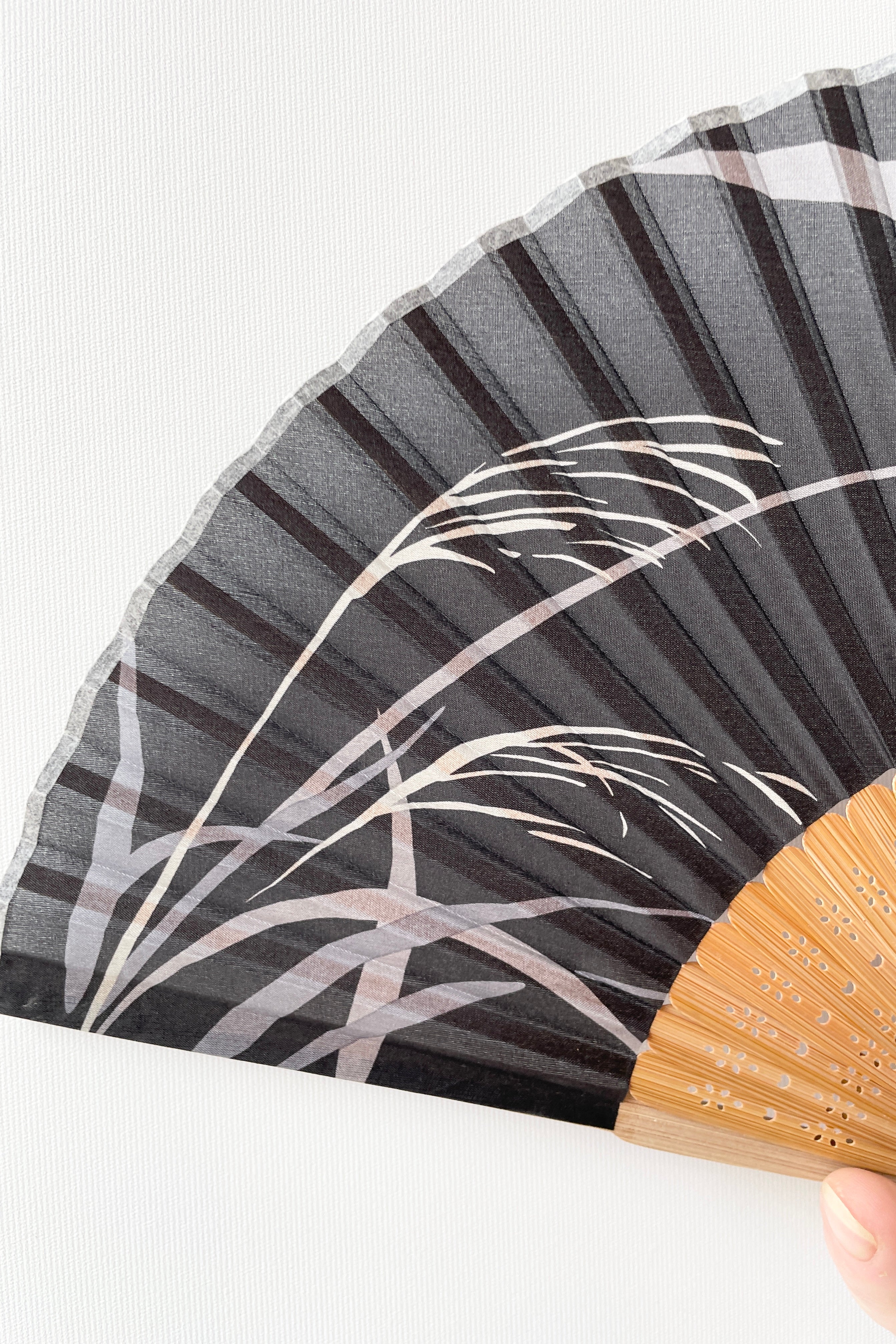 Detail of the Silk Fan Black with grey leaves.
