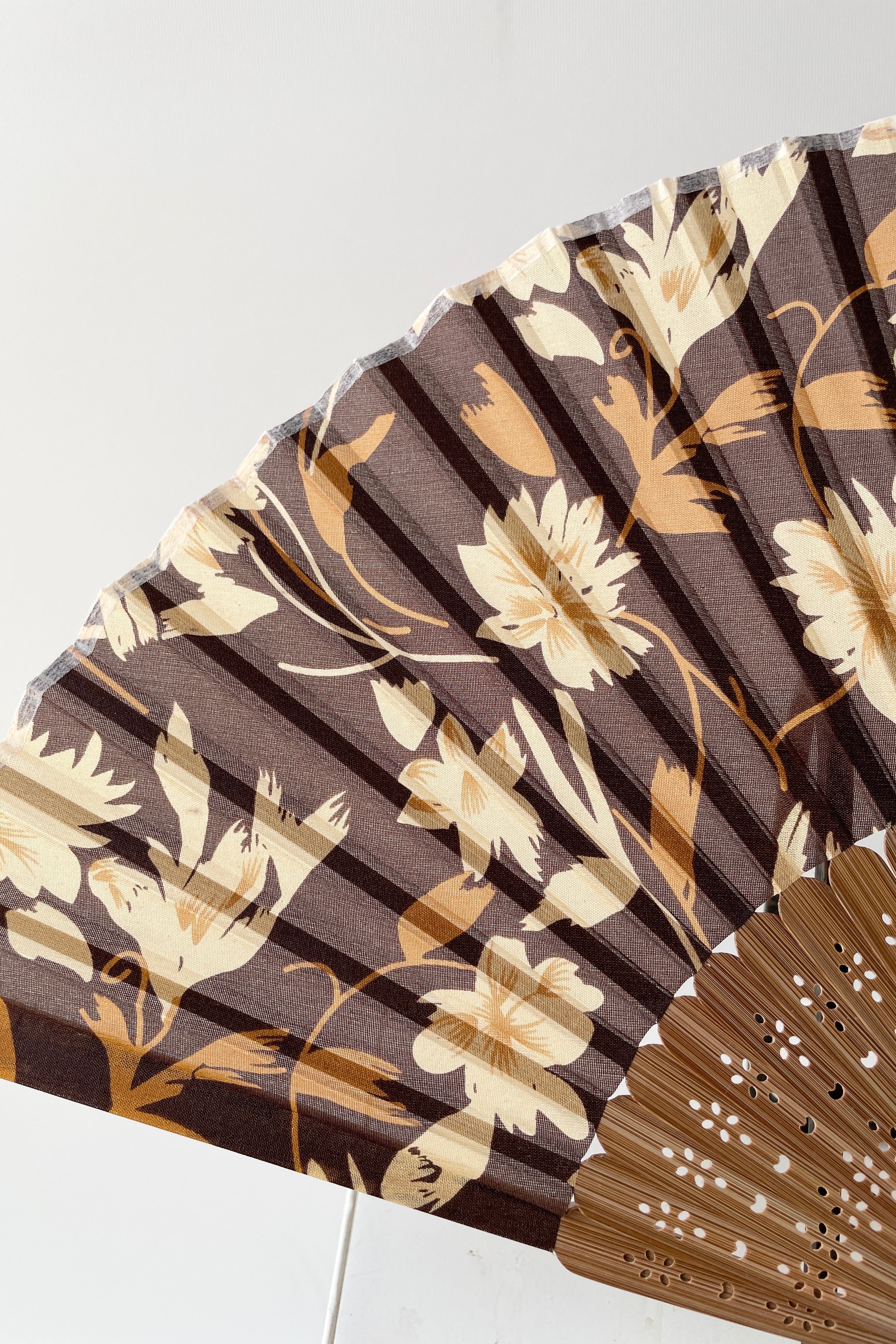 Detail of the silk brown flowers and bamboo on the silk fan at Sprout Home.