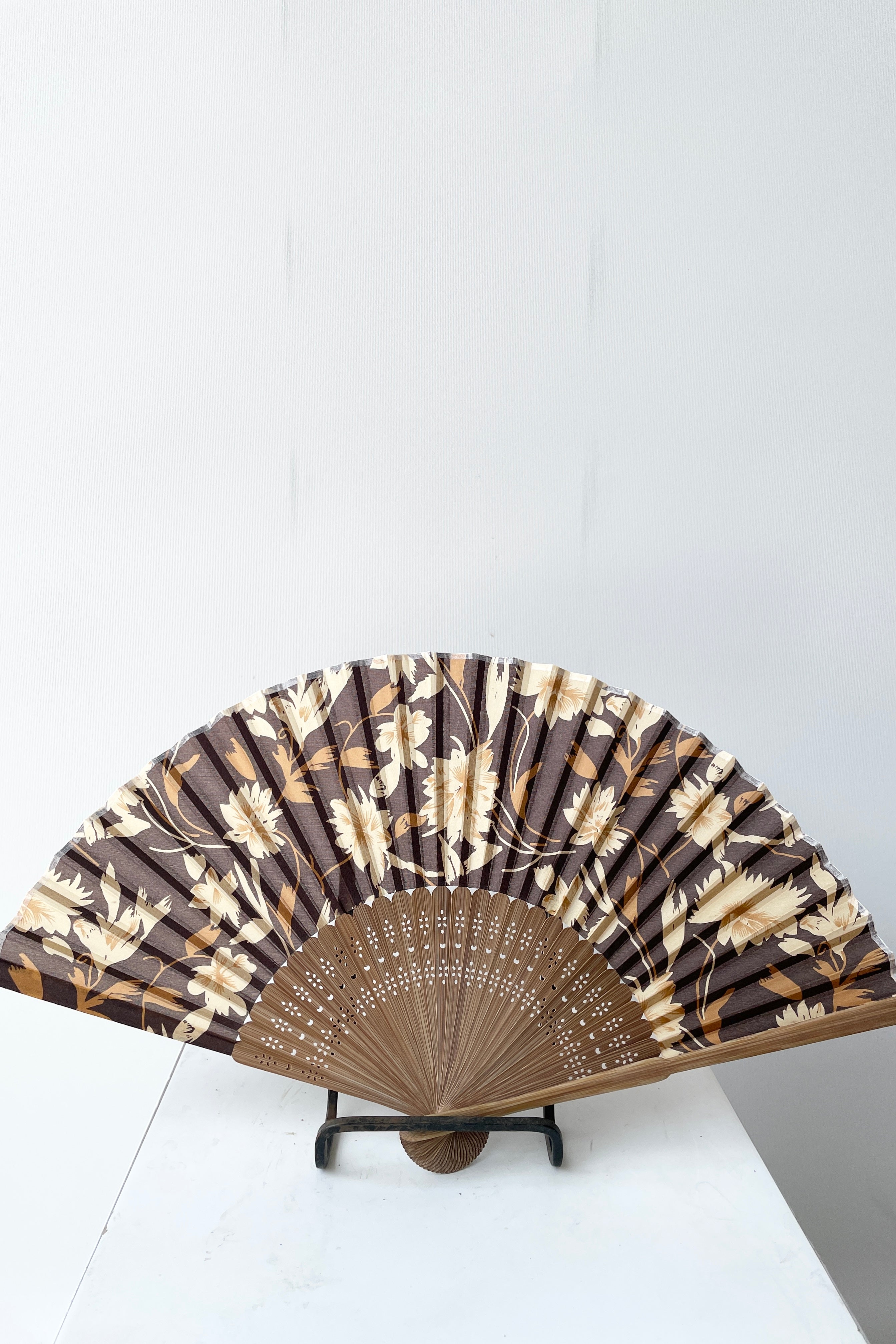 Silk fan brown flower and brown bamboo open and on a stand at Sprout Home.