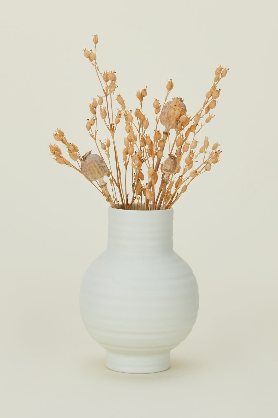 Bone colored Essential vase with some dried floral inside by Hawkins New York.