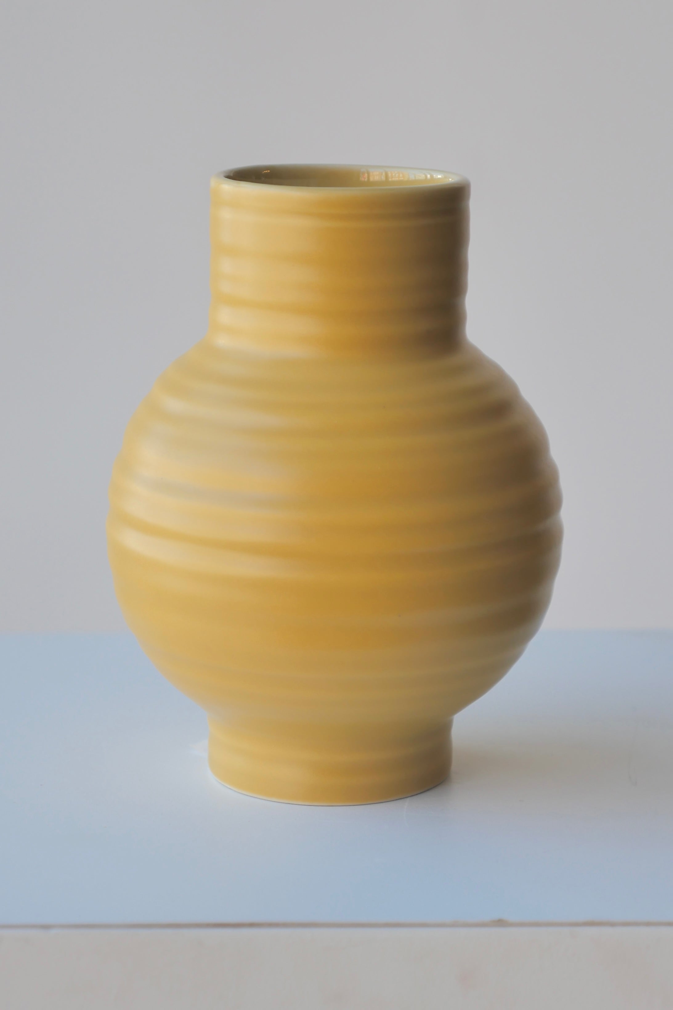 The Essential Vase in Mustard showing the horizontal ribs against white.
