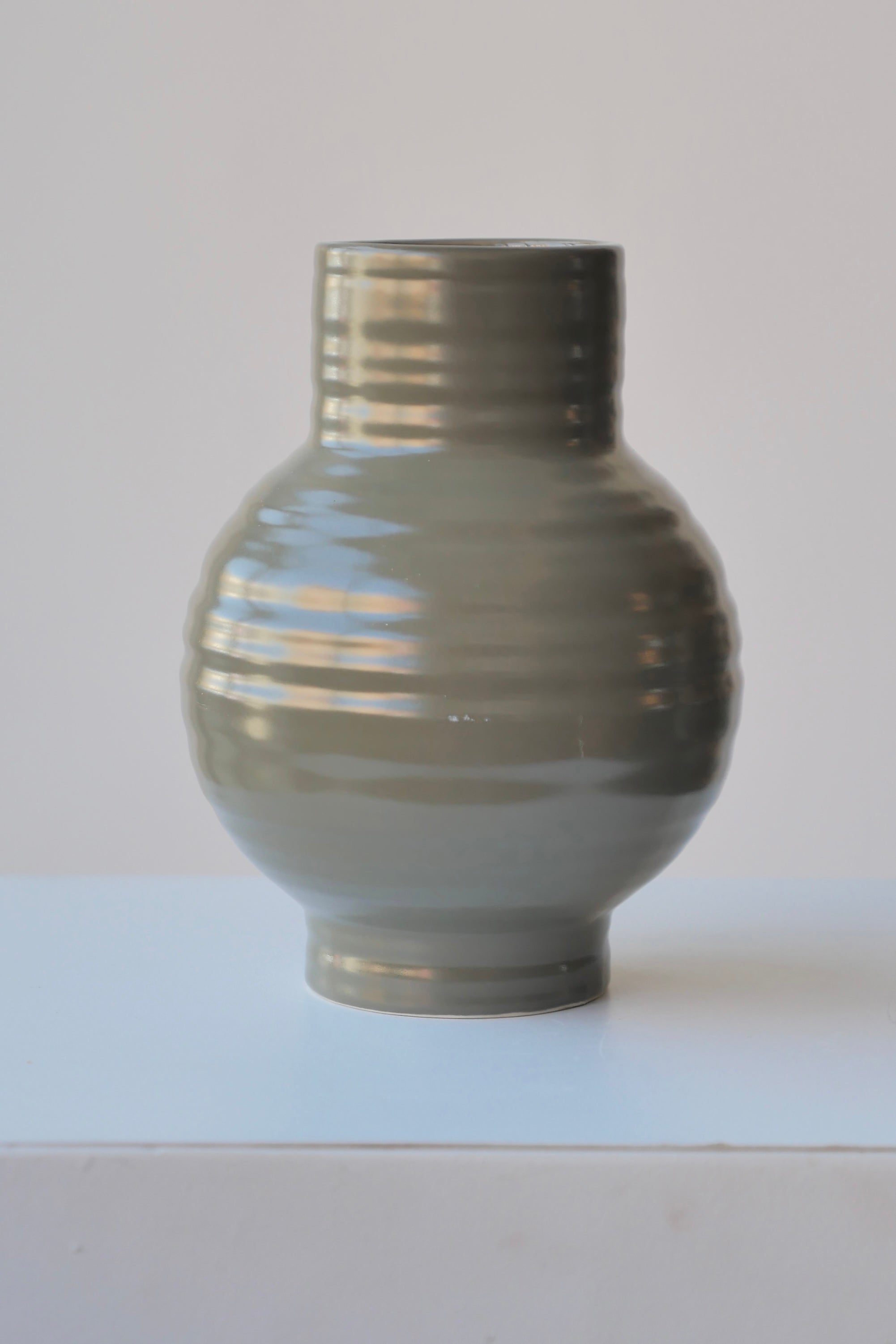 An Olive Essential Vase by Hawkins NY showing the horizontal ribbing.