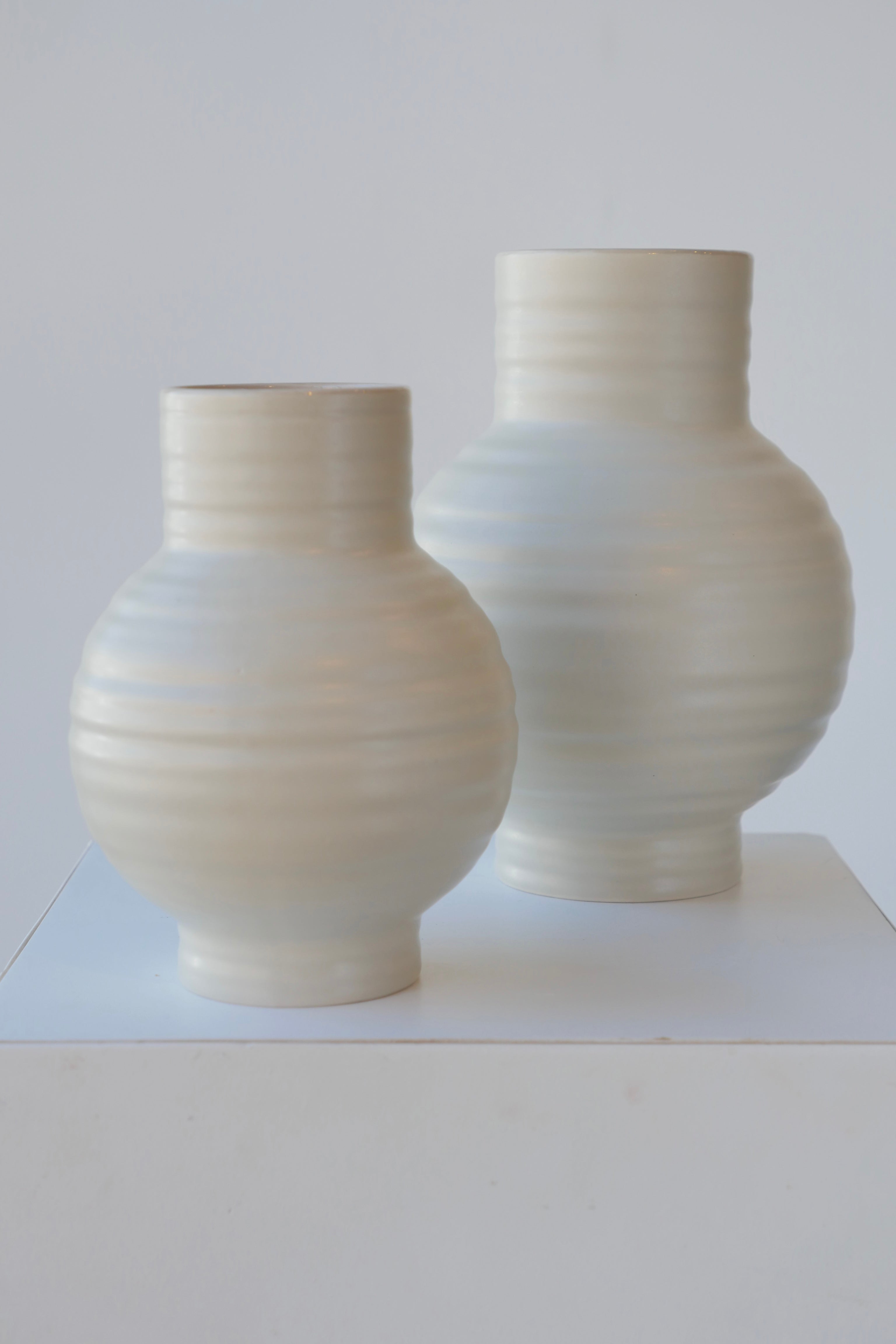 Pair of Essential Hawkins Light grey vases against white.