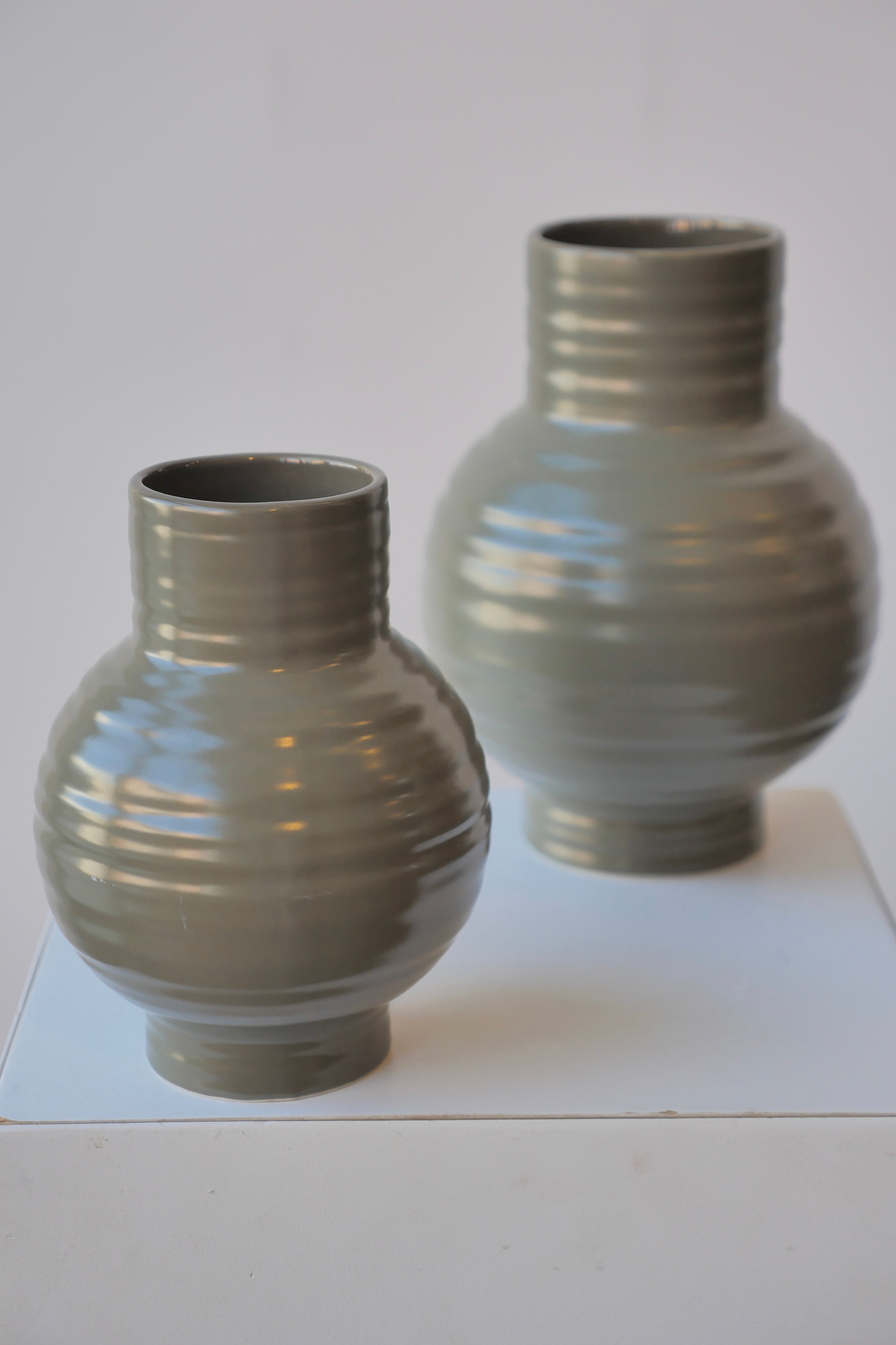 A pair of Essential Olive Ceramic vases by Hawkins NY against white.