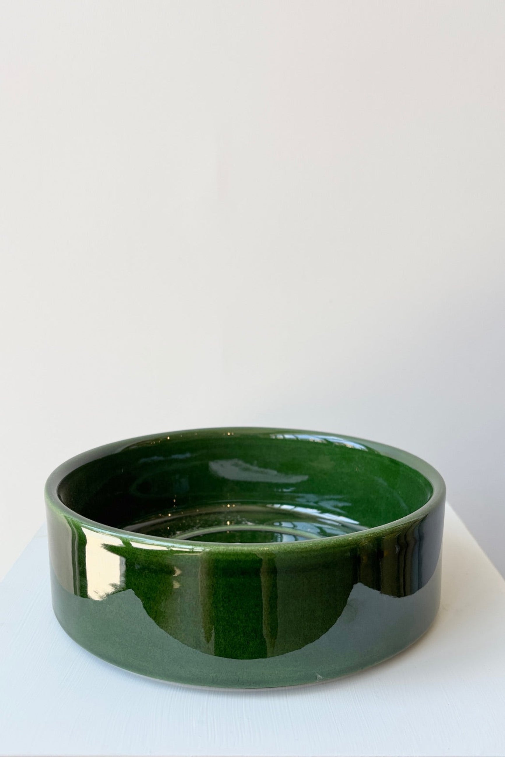 Emerald Green Hoff saucer against a white wall ©Sprout Home