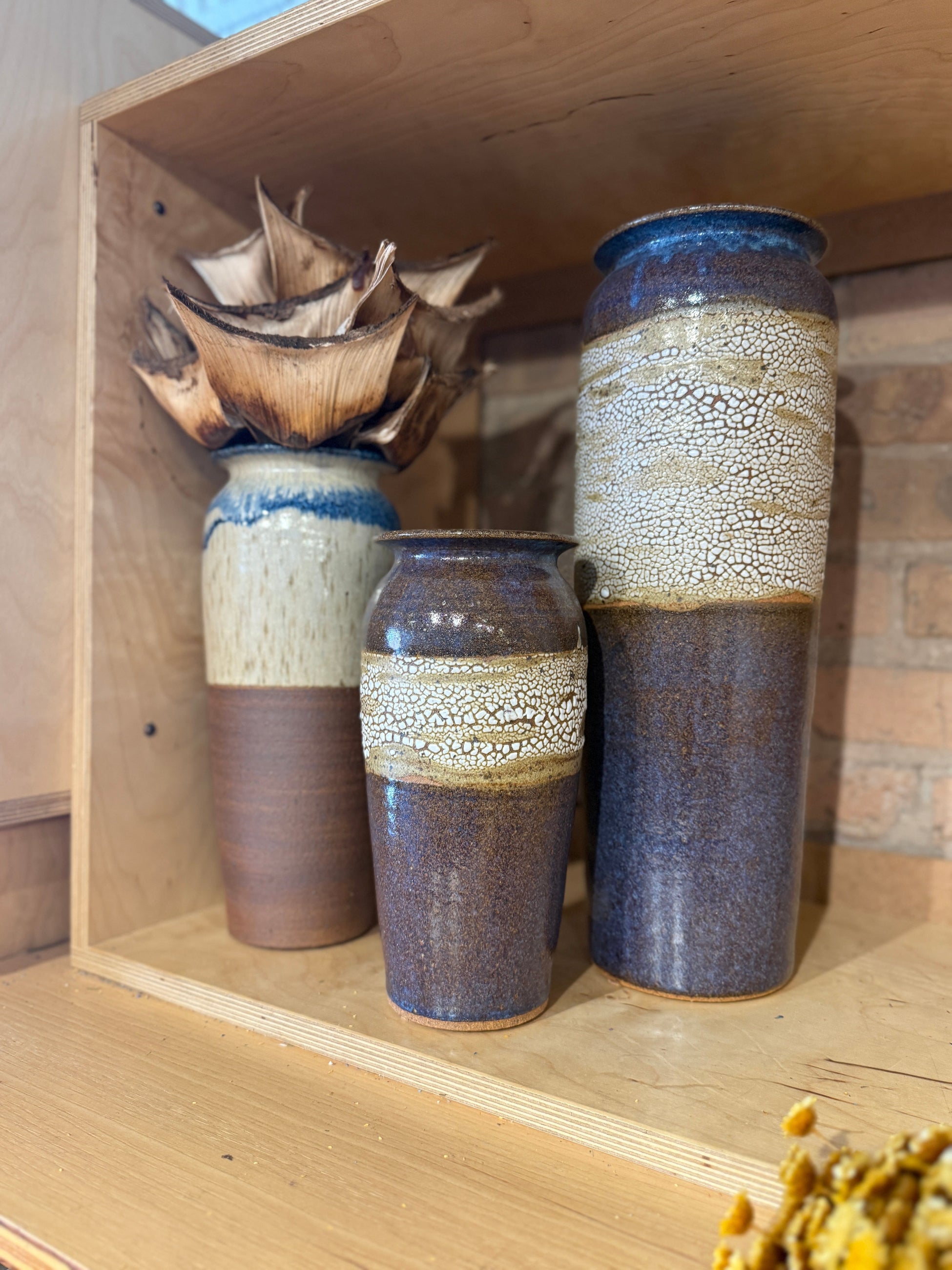 Bruning Pottery Vases in various shades of purple and off-white and two with crackle on display at Sprout Home Floral ©Sprout Home