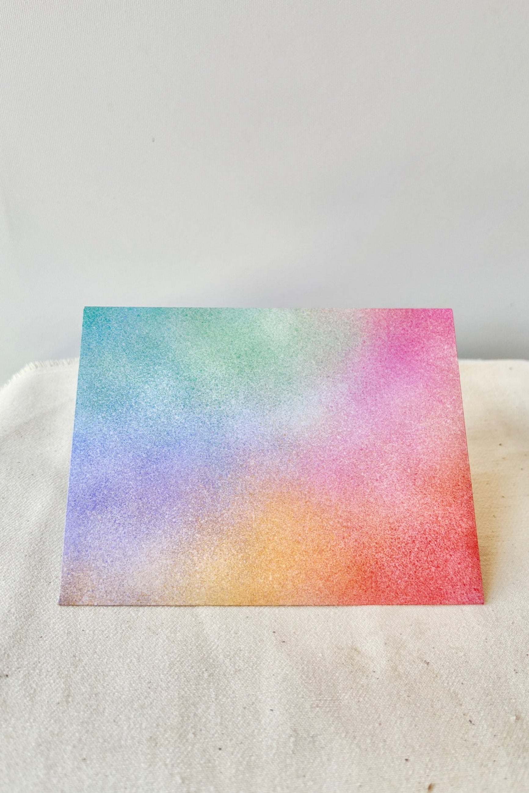 The envelope that comes with the Moon card painted in pastel color against a white background