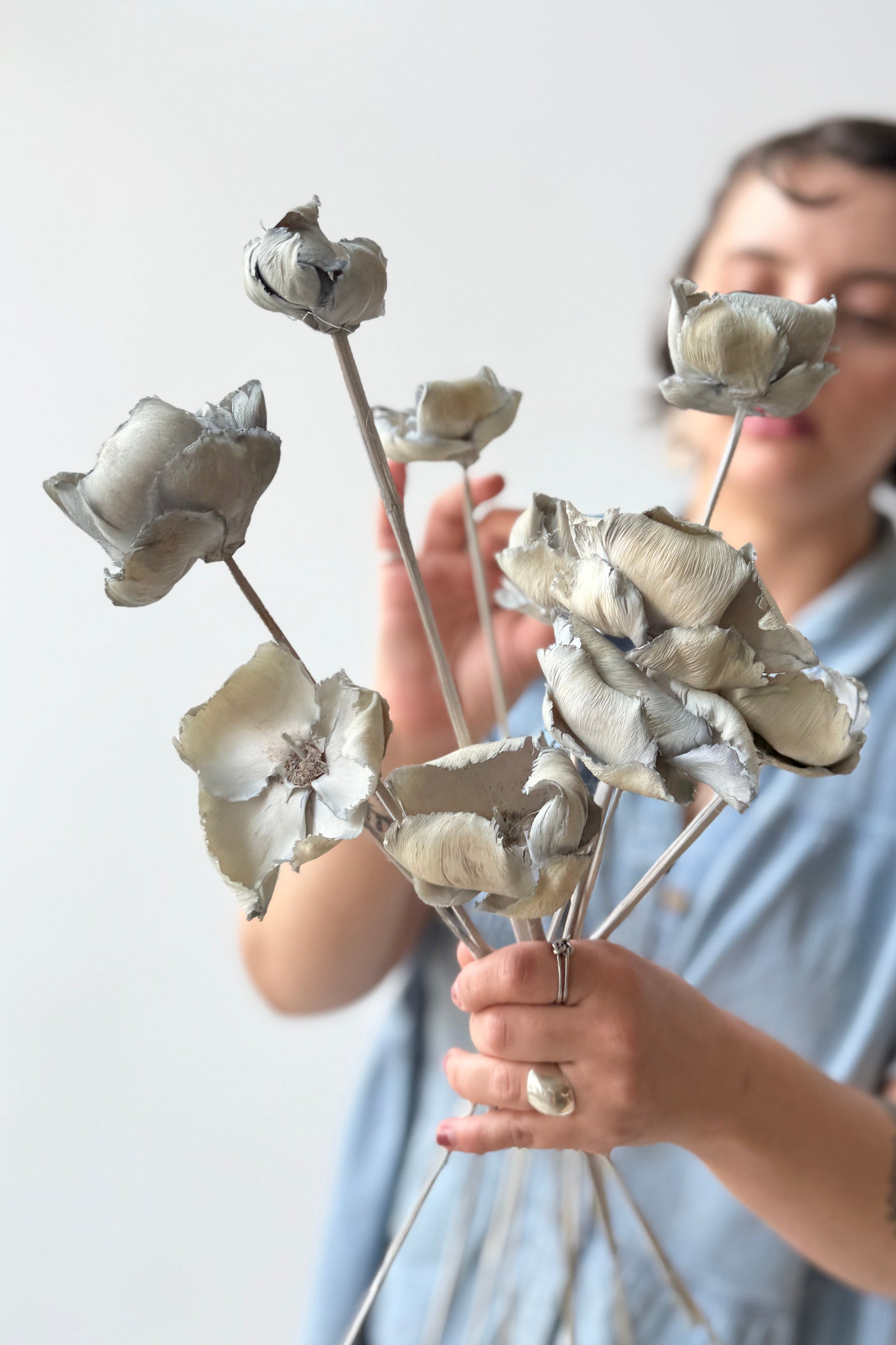 Person holding a bouquet of Palm Cap Gray Blue Pastel Preserved Bunch against a plain background ©Sprout Home