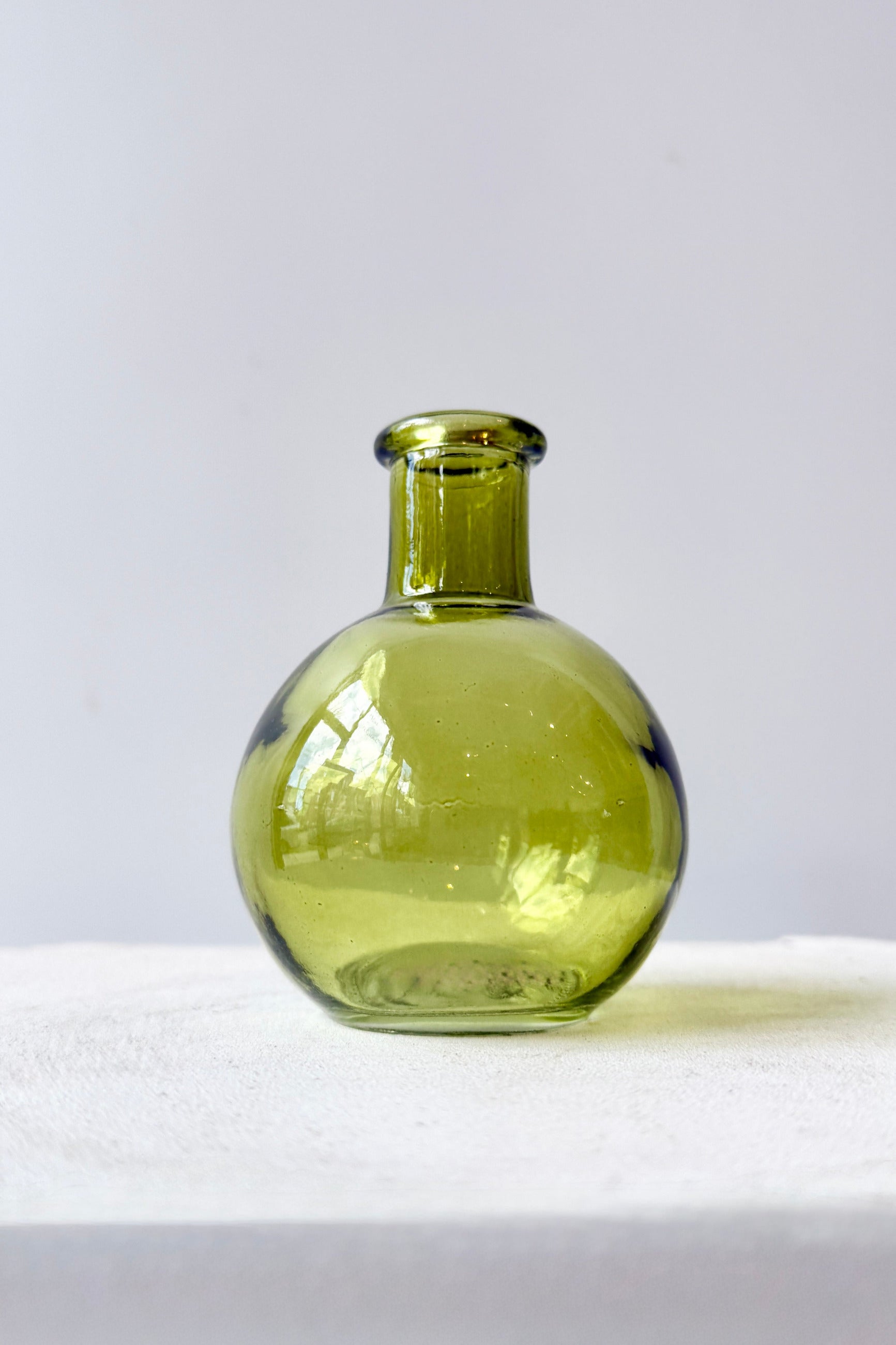 Round Green Bud Vase on a white surface with a light gray background ©Sprout Home