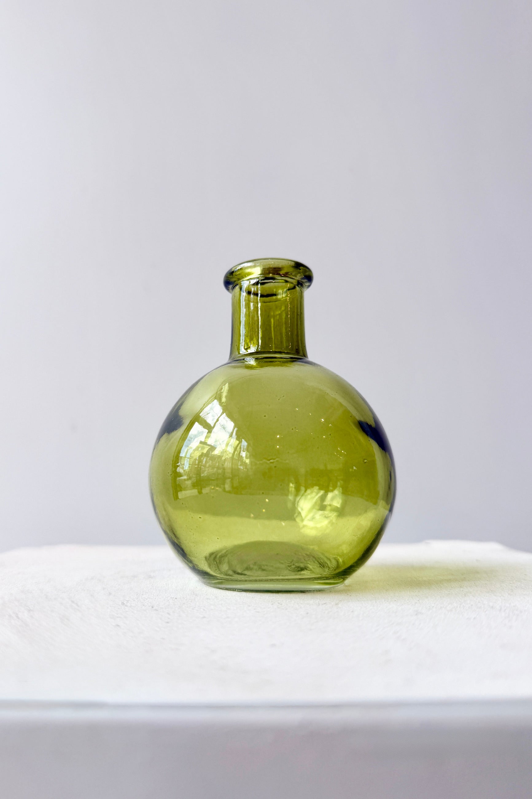 Round Green Bud Vase on a white surface with a light gray background ©Sprout Home