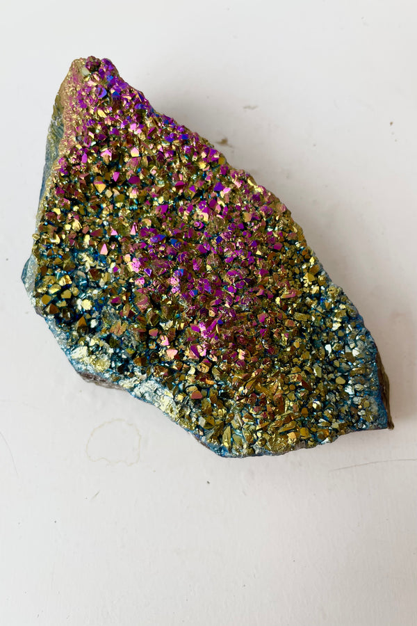 Metalized Amethyst with pink, gold and blue coloration against white background