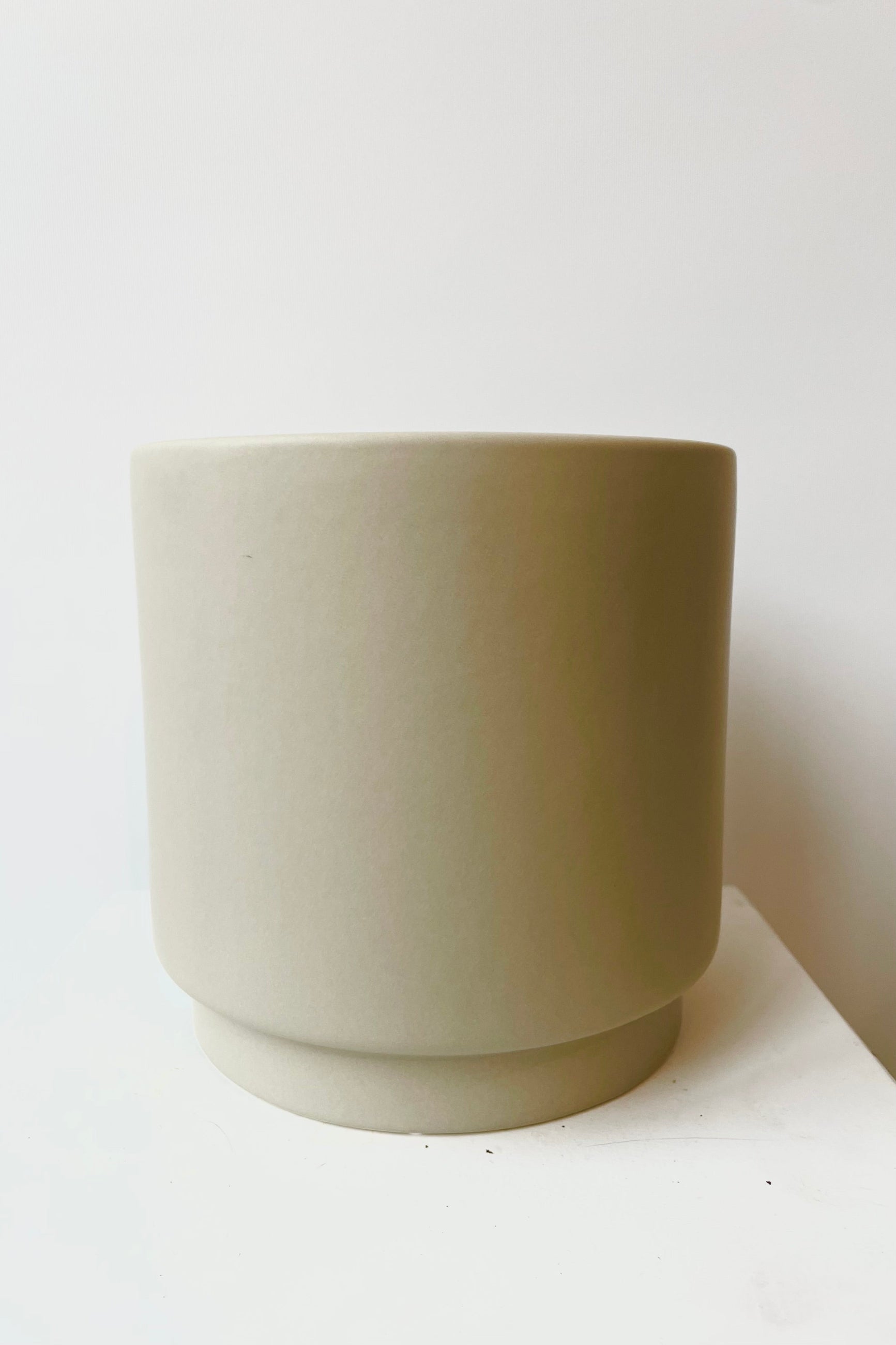 Beige ceramic urn shaped cachepot against white background ©Sprout Home
