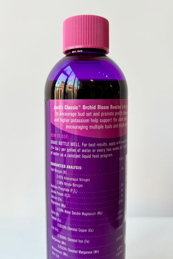 Backside of Jacks Classic 8oz liquid orchid fertilizer in purple bottle against white background 
