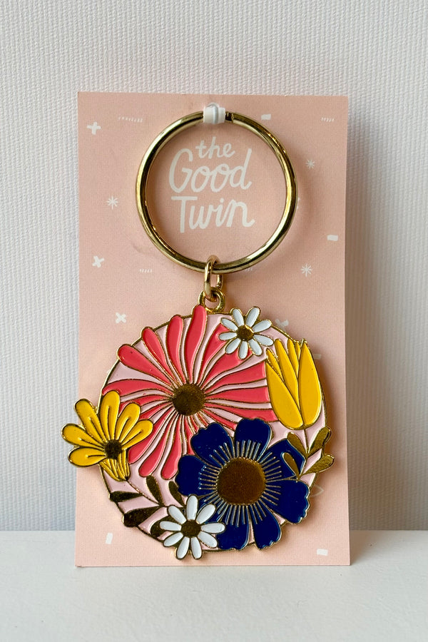 Cottage floral keychain featuring round floral motif in pink, yellow and blue on gold keychain