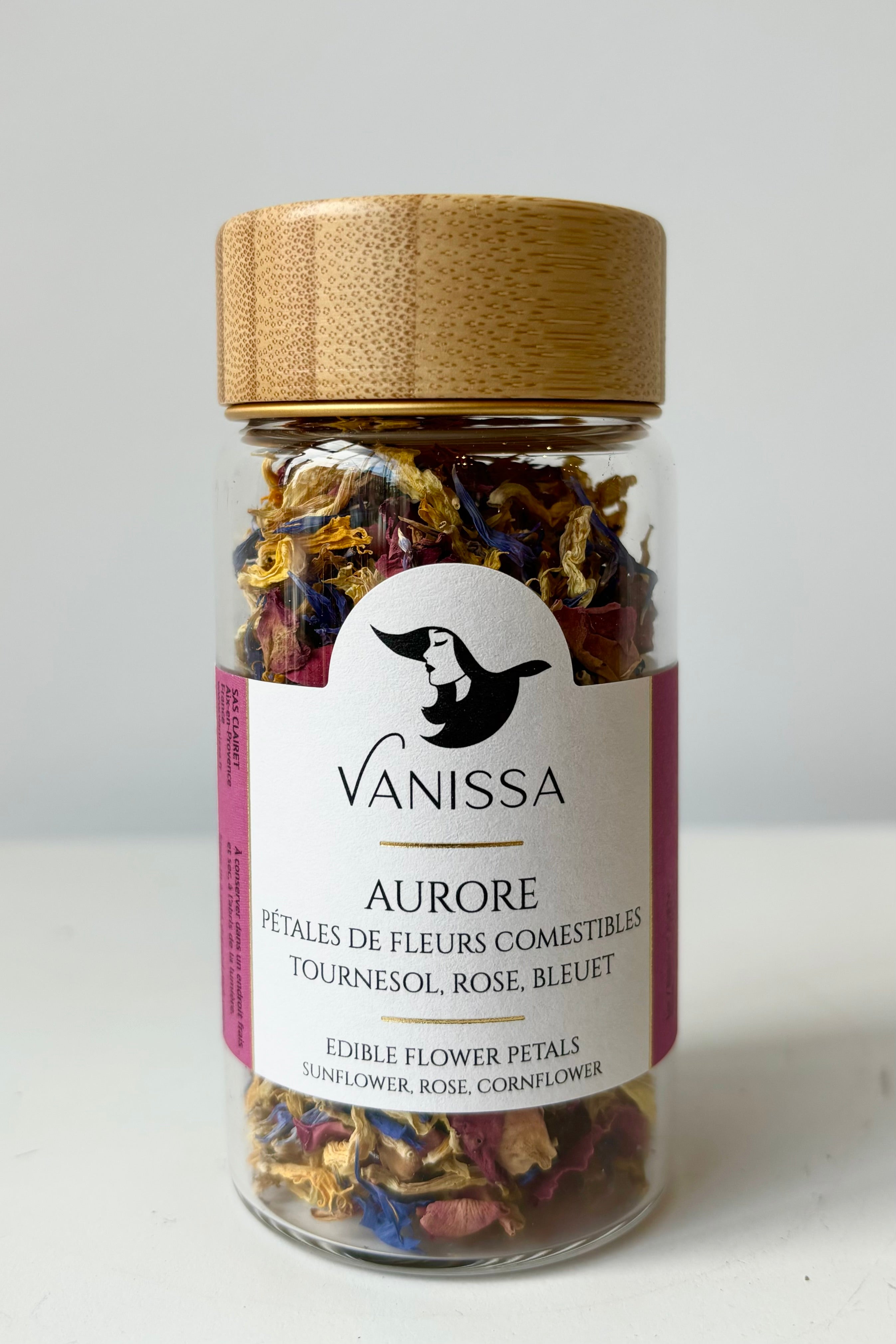 Front view of glass jar with dried flower petals composed of Cornflower, sunflower and rose petals against white background