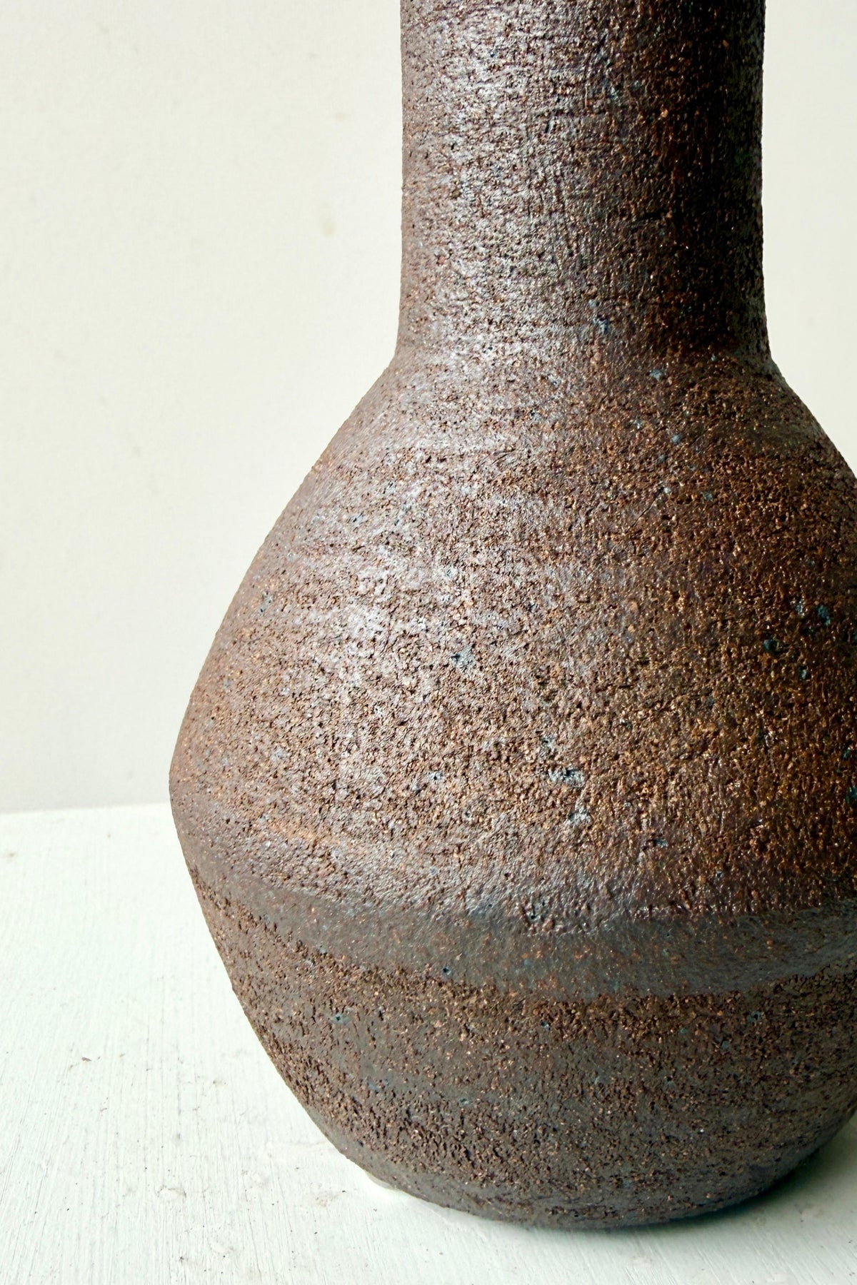 an upp close image of the Long Neck Ceramic Vase No. 2 Dark Brown Medium showing the finish ©Sprout Home