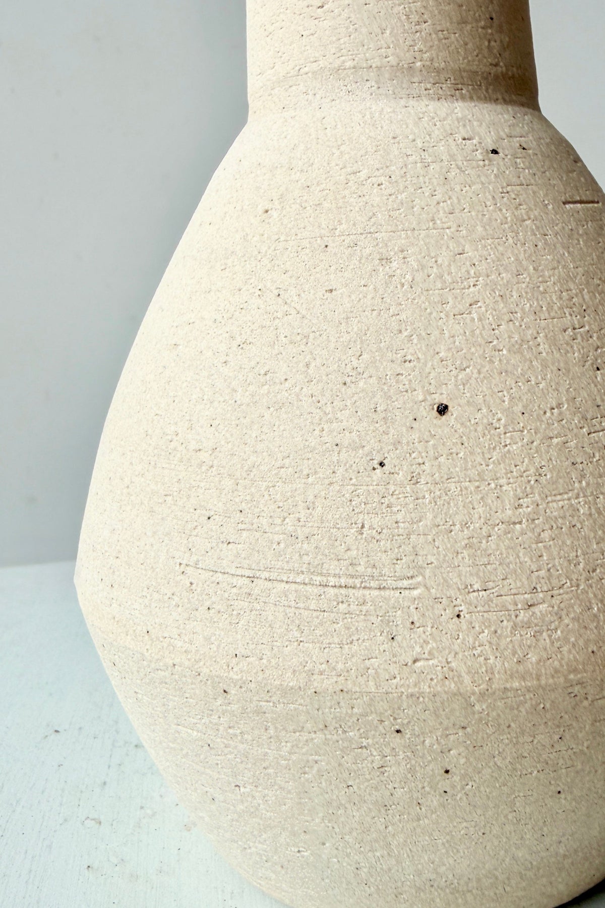 up close image of the Long Neck Ceramic Vase No. 2 Cream Large showing the finish. ©Sprout Home