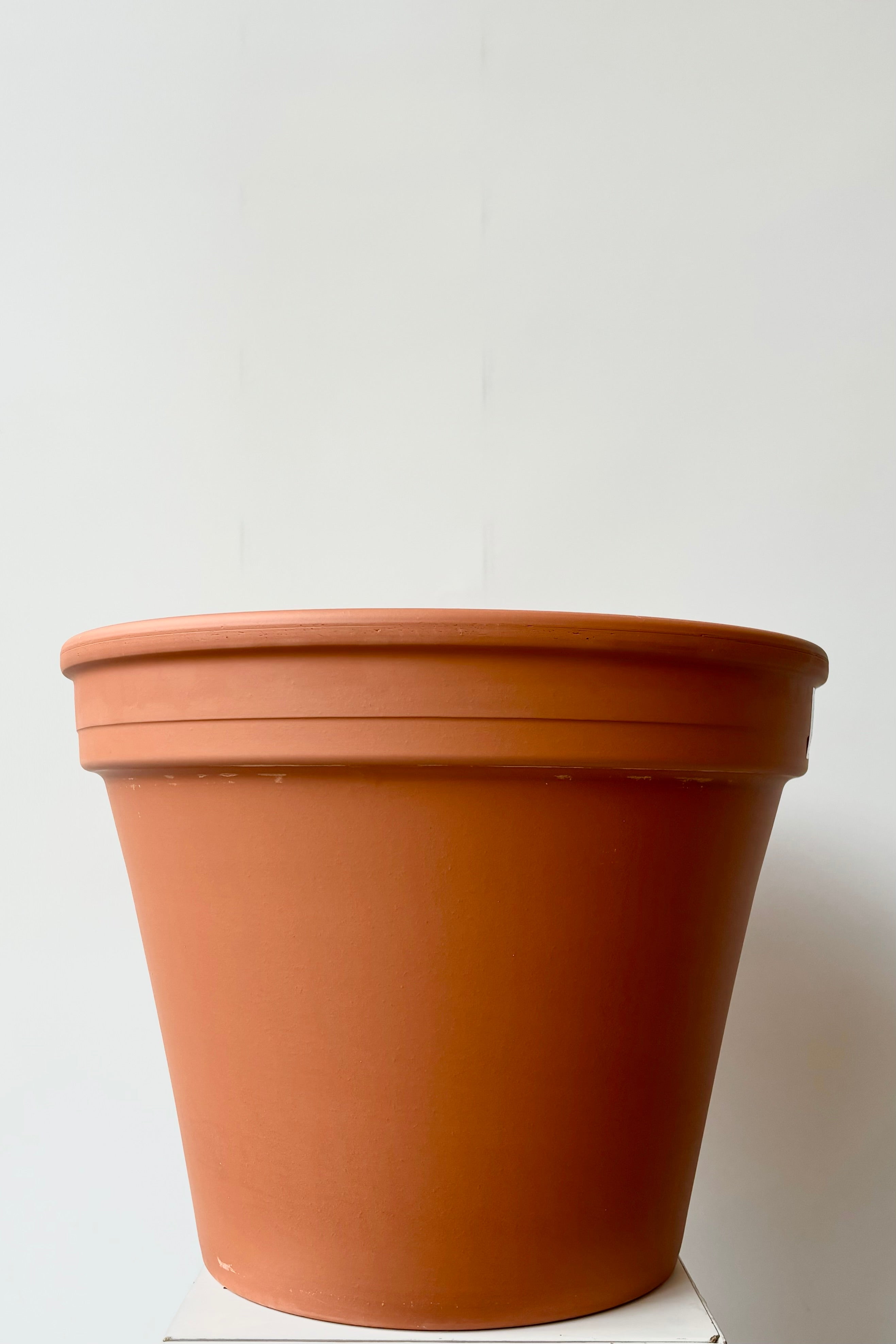 Terra cotta clay pot sixteen inch against white background.