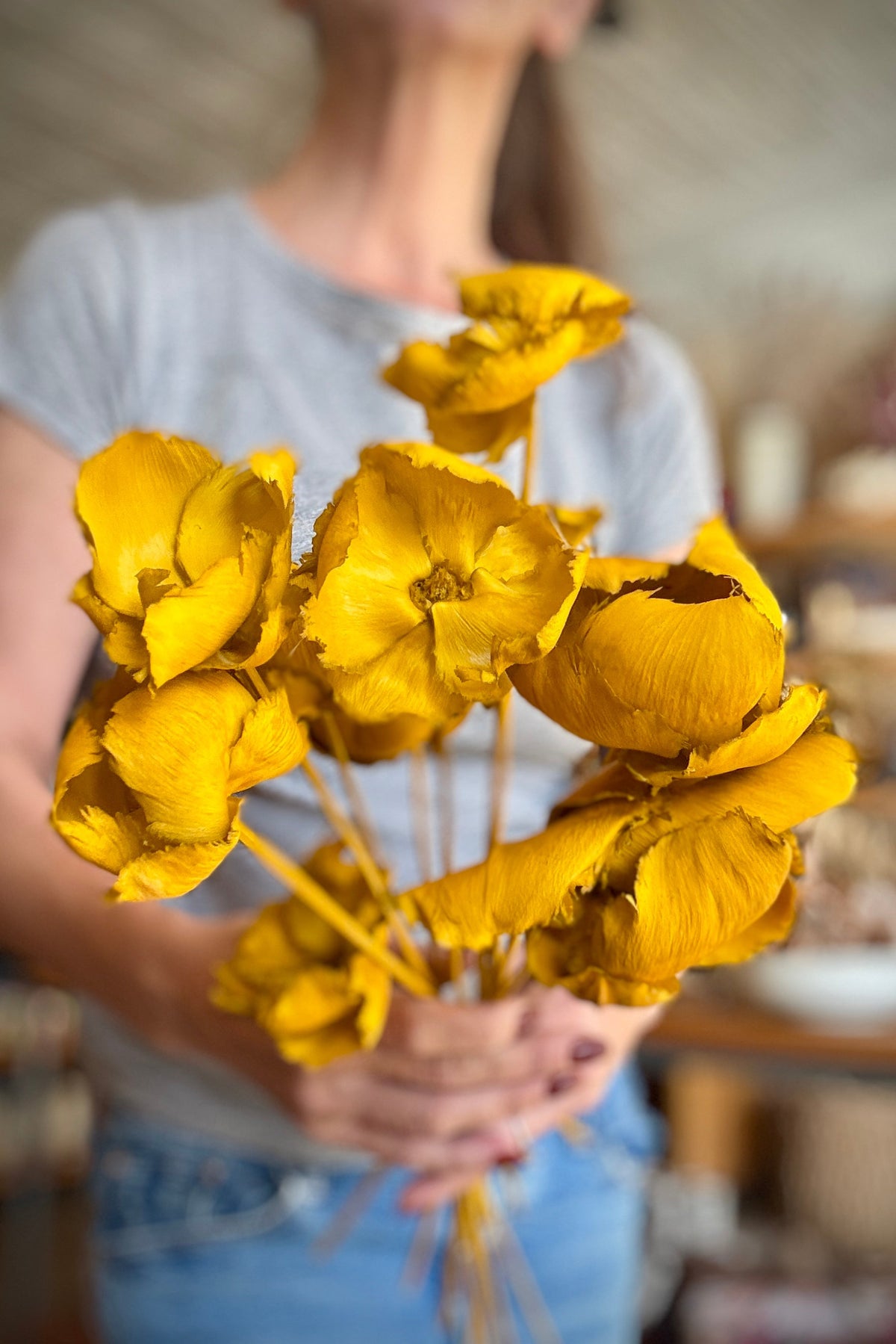 Palm Cap Ochre Pastel Preserved Bunch being held in hand with a blurred background ©Sprout Home