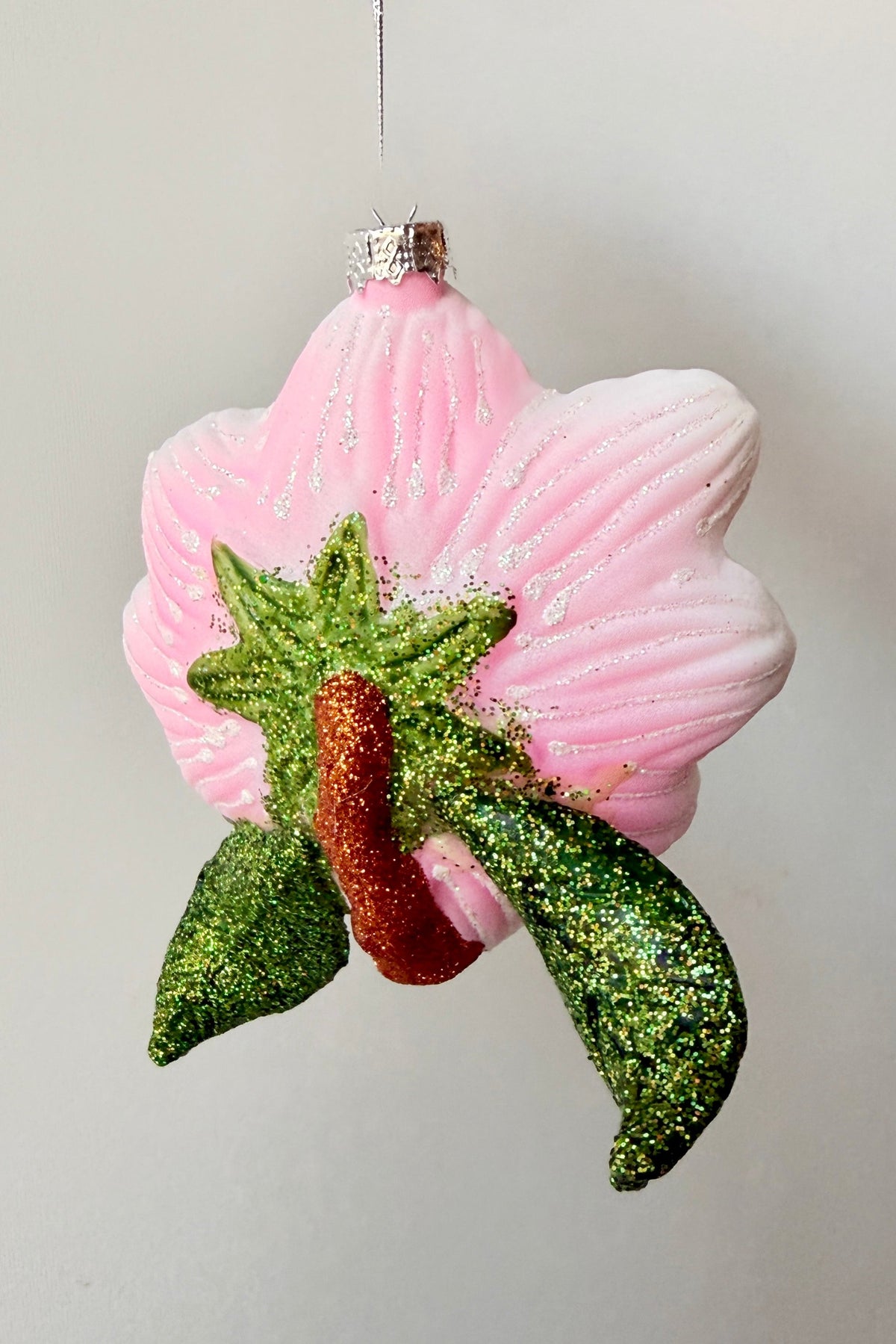 the backside of the Southern Magnolia Ornament showing on off the pink and green glitter glass areas ©Sprout Home