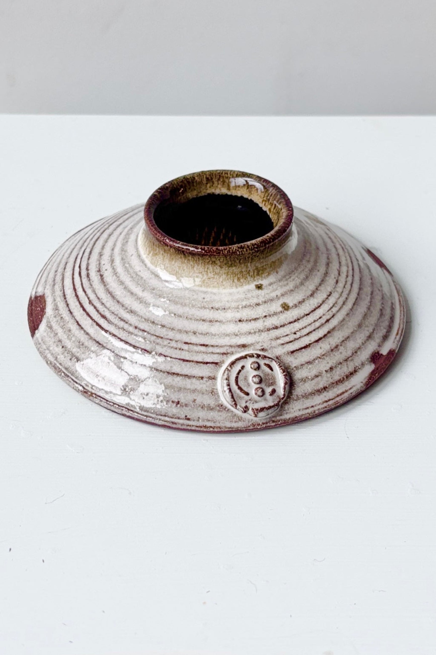 Side view of white glazed Ikebana flower vase with floral frog on a white surface ©Sprout Home