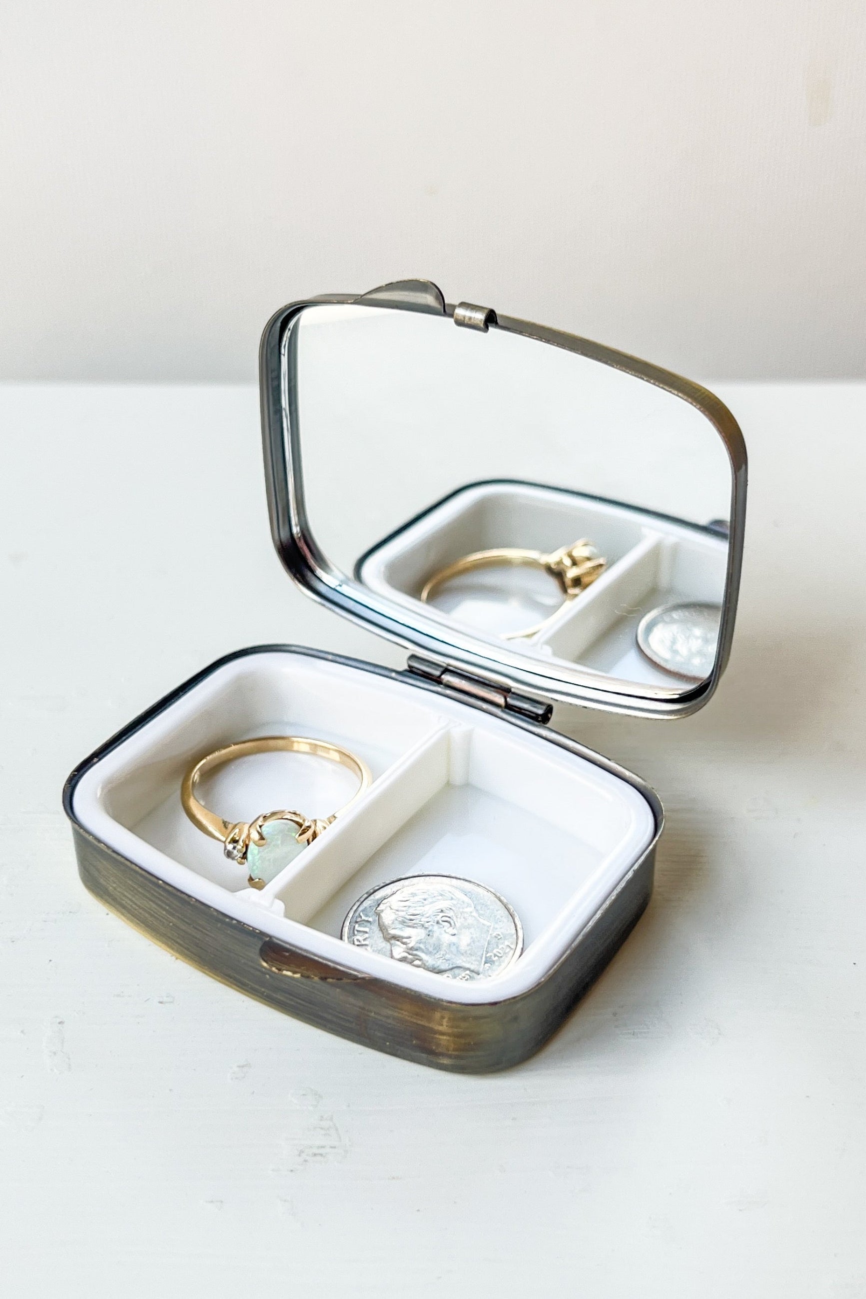 Open jewelry box with gold rings inside on a white surface ©Sprout Home