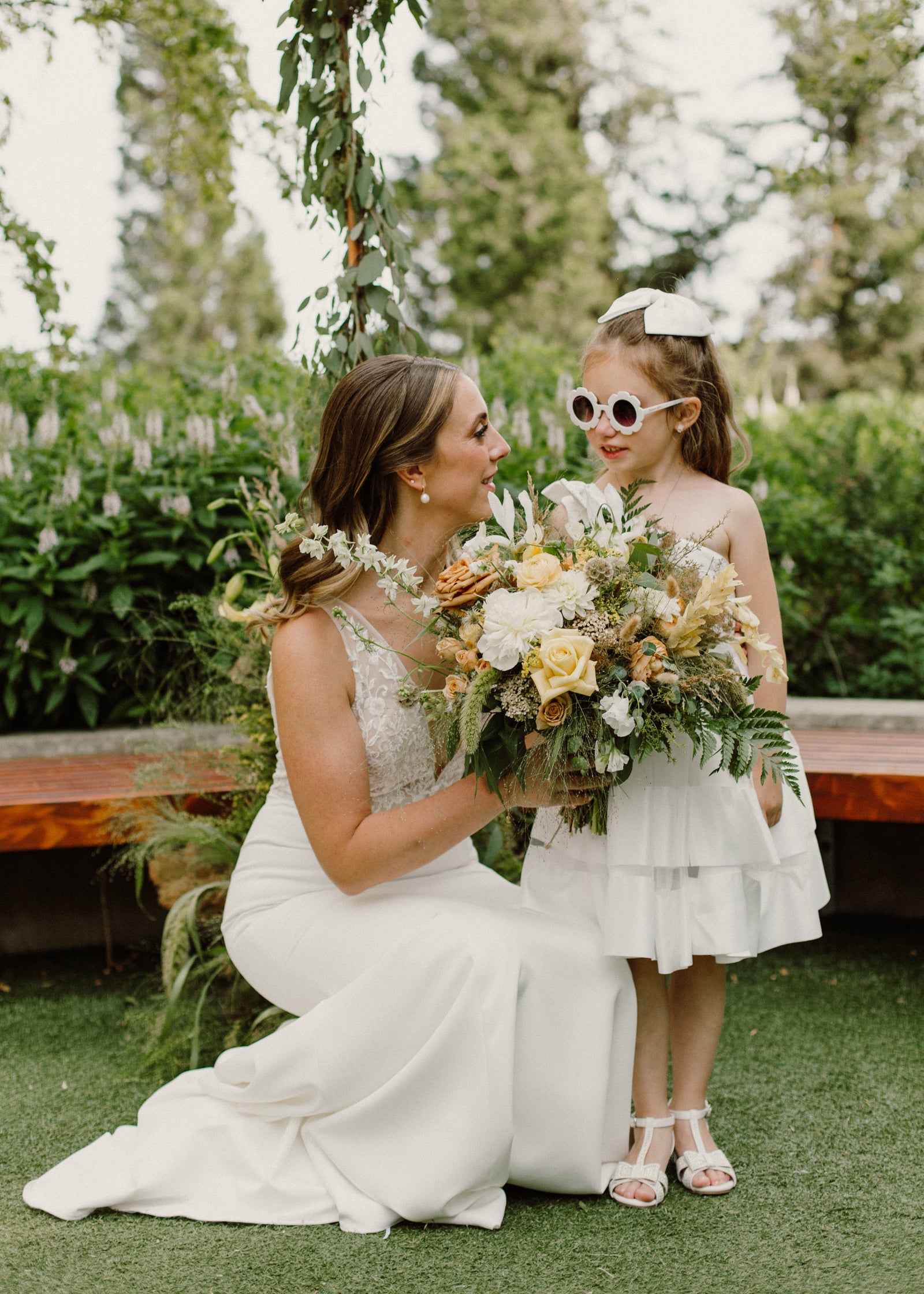 Julia & Vlad's wedding with the bride holding a bouquet next to a young person. Floral by Sprout Home. Photograph by Nicole Donnelly Photography