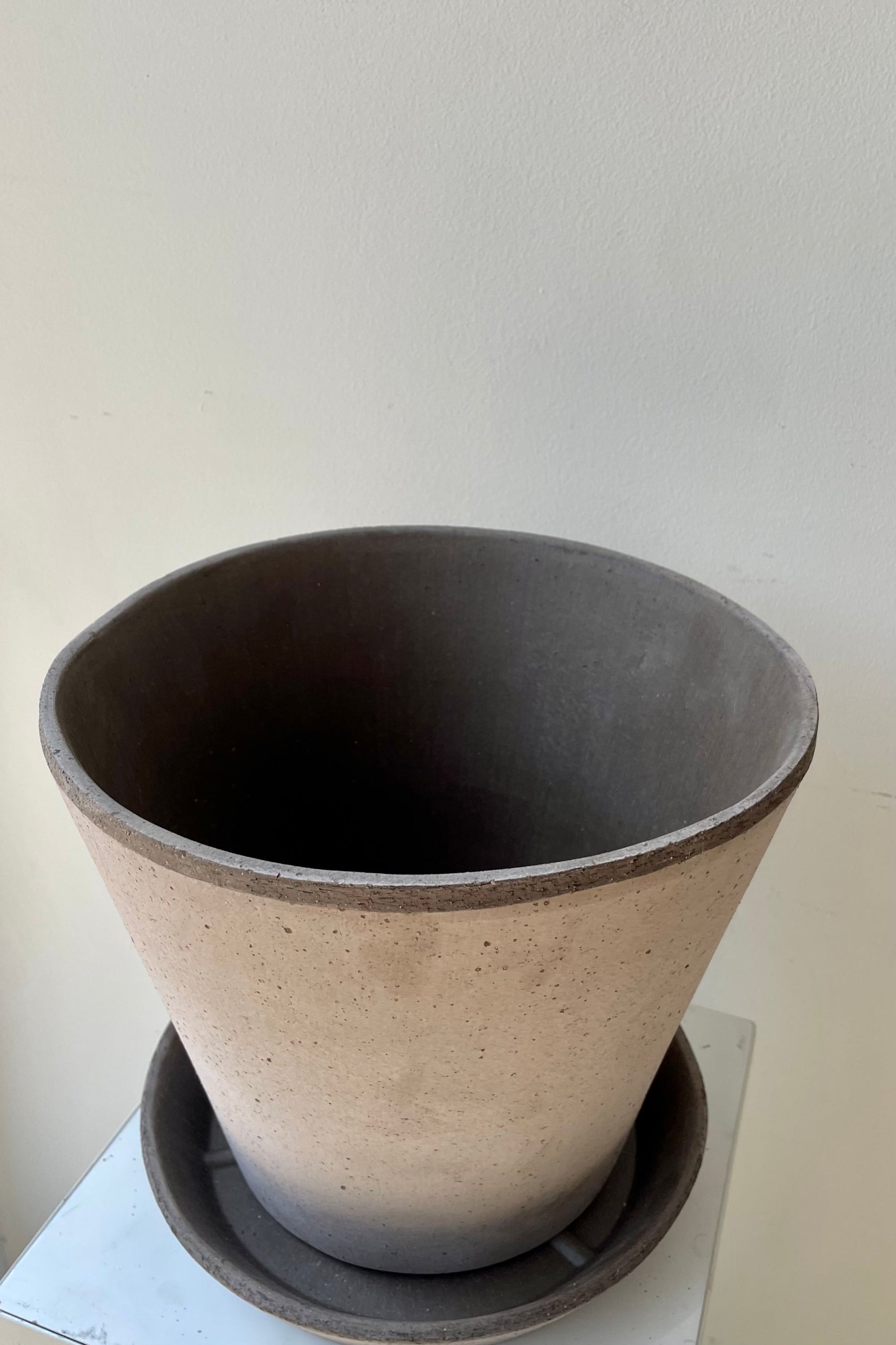 Photo looking down at Julie Pot & Saucer grey 9.8” against a white wall ©Sprout Home