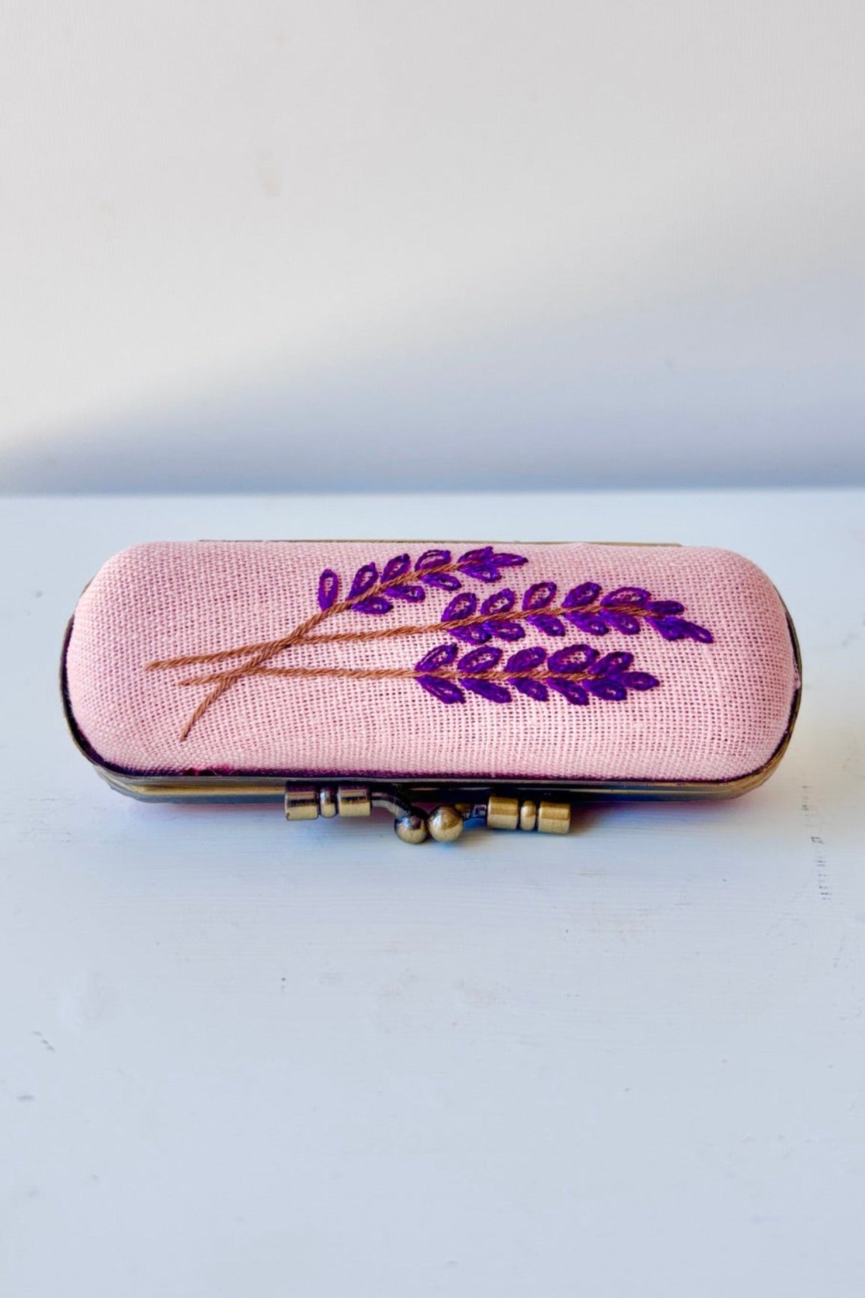Decorative case with floral embroidery on a lavender background ©Sprout Home