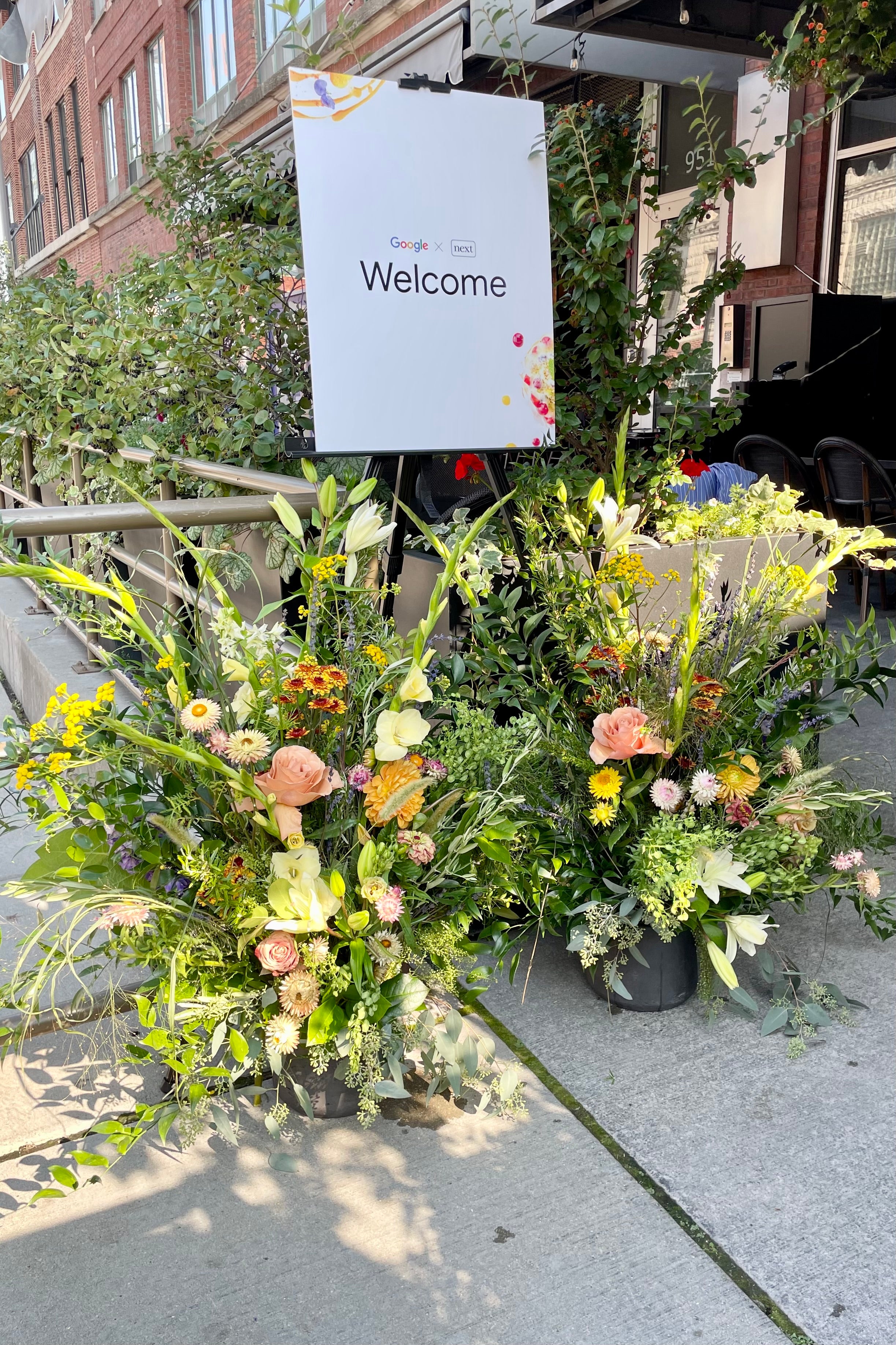 Large welcome arrangements flank a welcome sign for a corporate Google event at Next Restaurant. Photograph by Sprout Home.