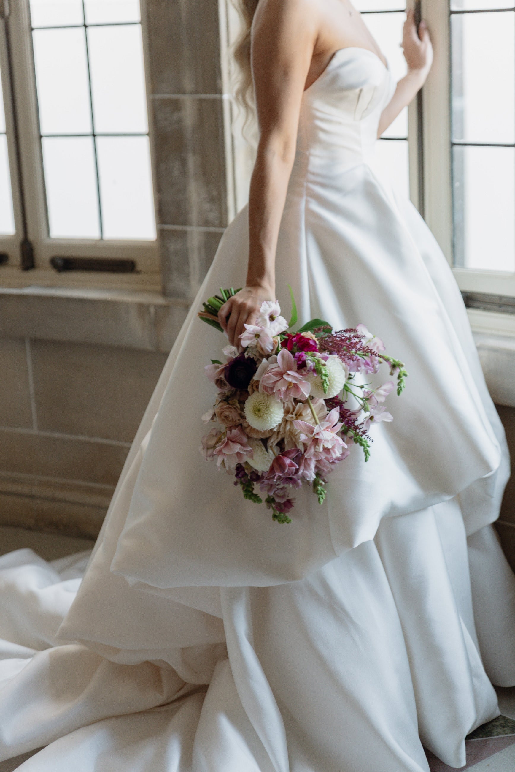 A soft pink bridal bouquet created by Sprout Home Floral held in hand by the bride in front of a window. ©Shannon St. Clair - @shanstclair
