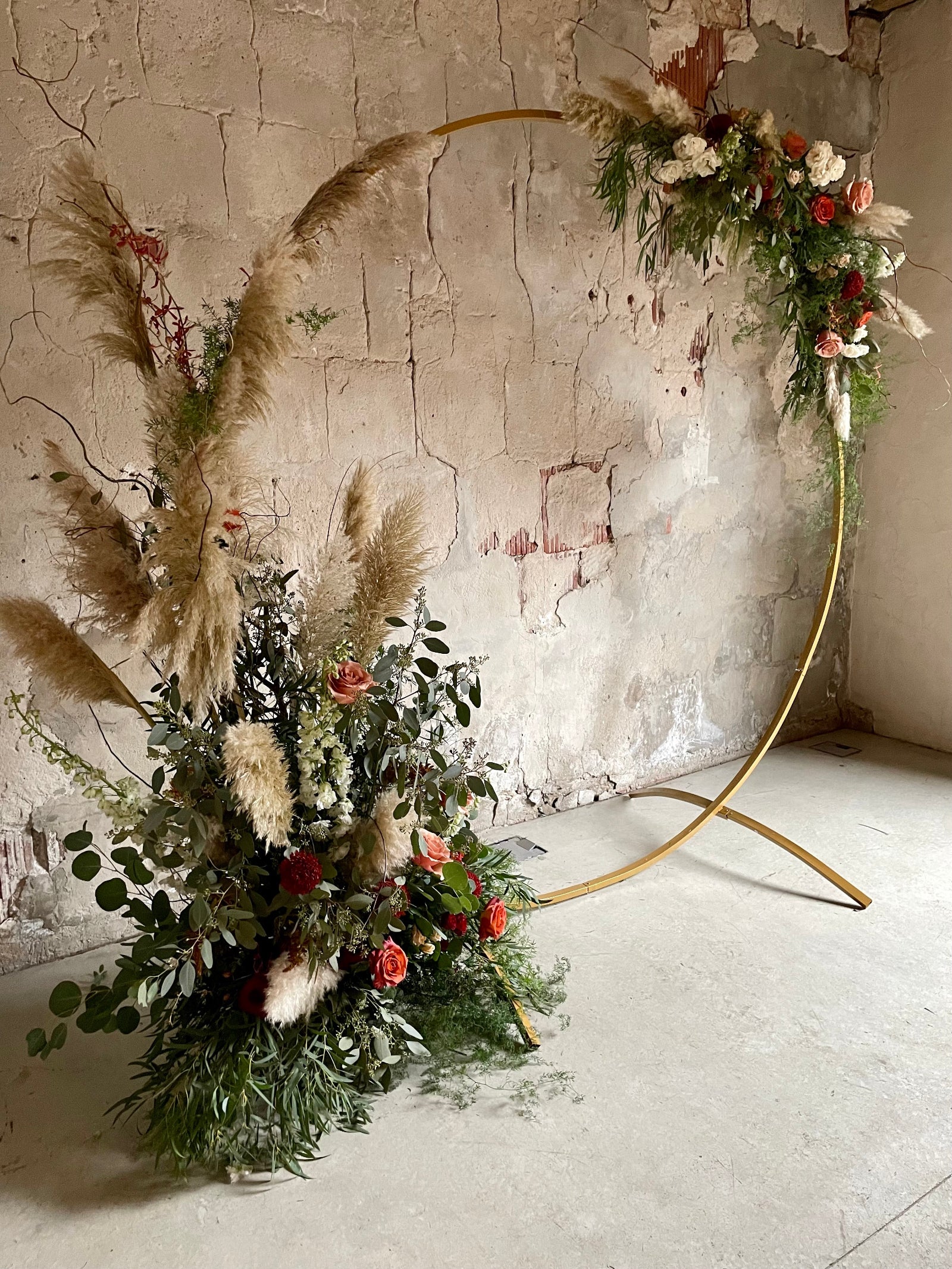 Jennifer Yannick wedding floral by Sprout Home with a golden circle ceremony arch with pampers grass greens and warm colored floral at the Charcoal Factory in Chicago.