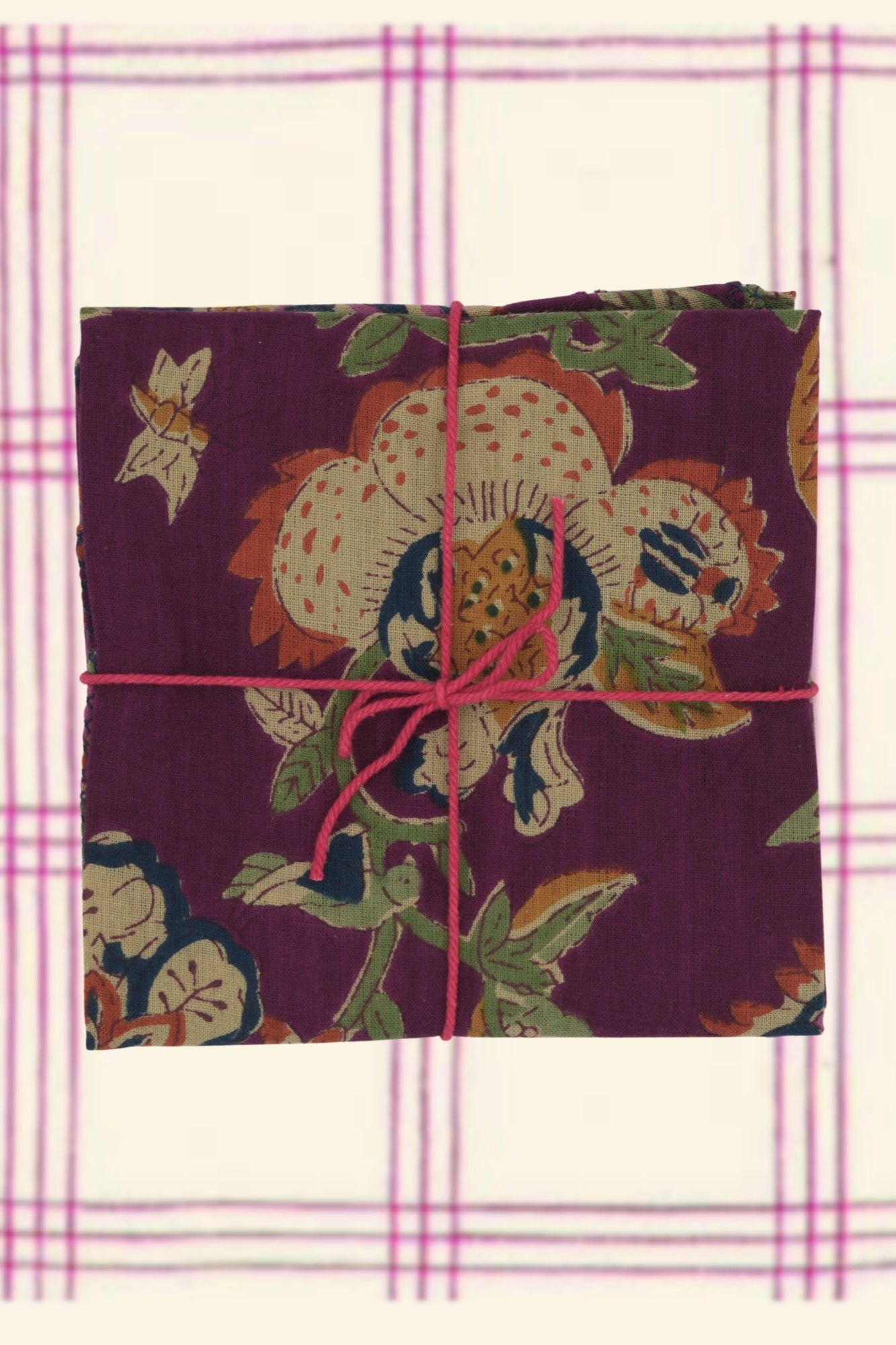 Photo of floral patterned napkins folded on a neutral plaid background ©Suzette a Table