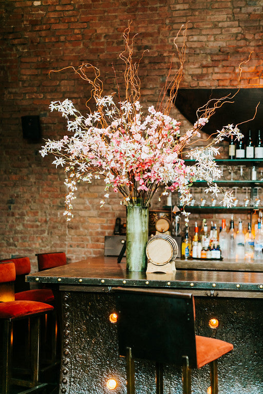 Bar arrangement with white and pink flowering branches by SPROUT HOME. Photo by Danfredo Photos Films.
