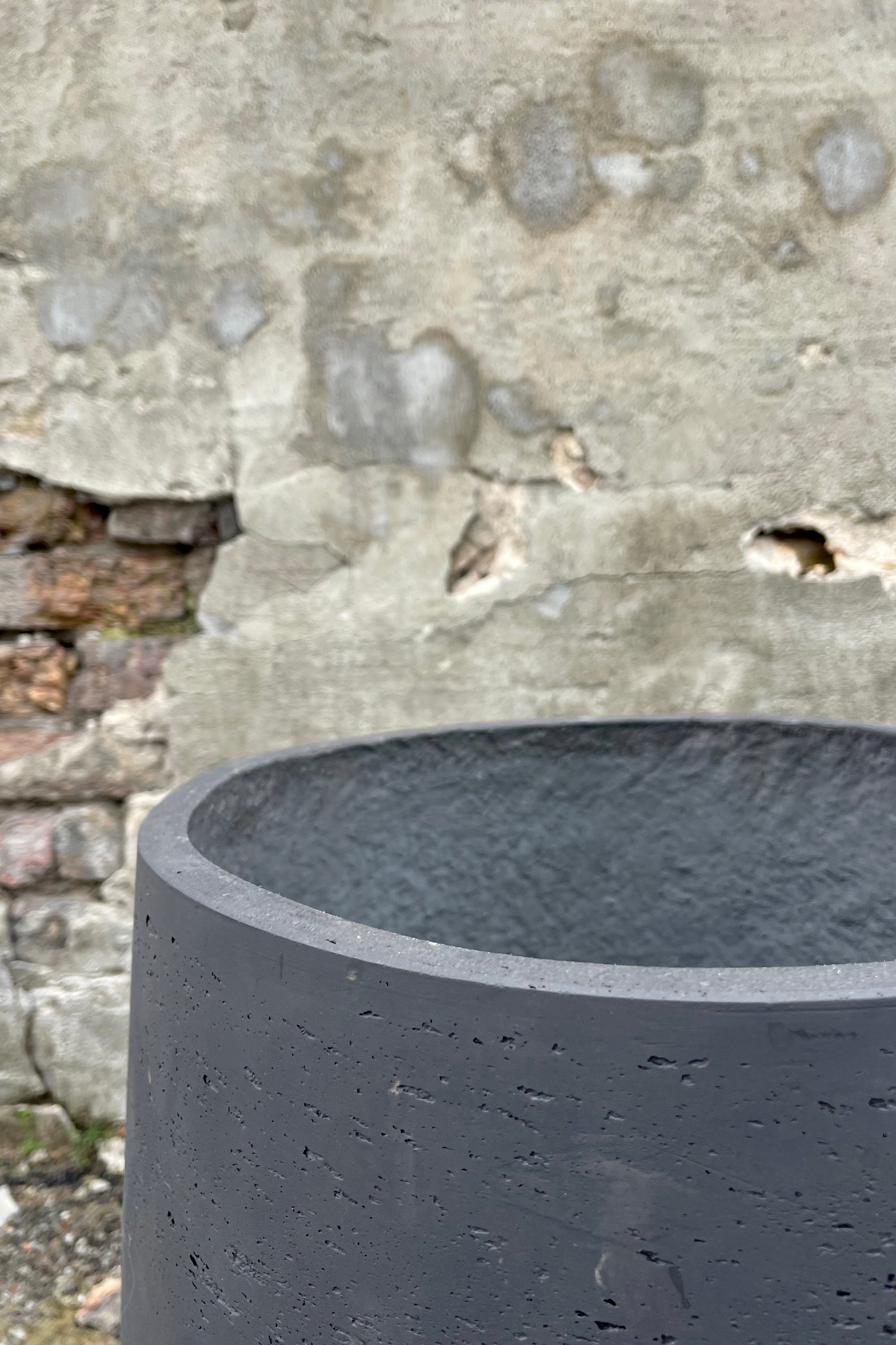 Above Photo of matte black textured planter Patt Pot with low feet stand