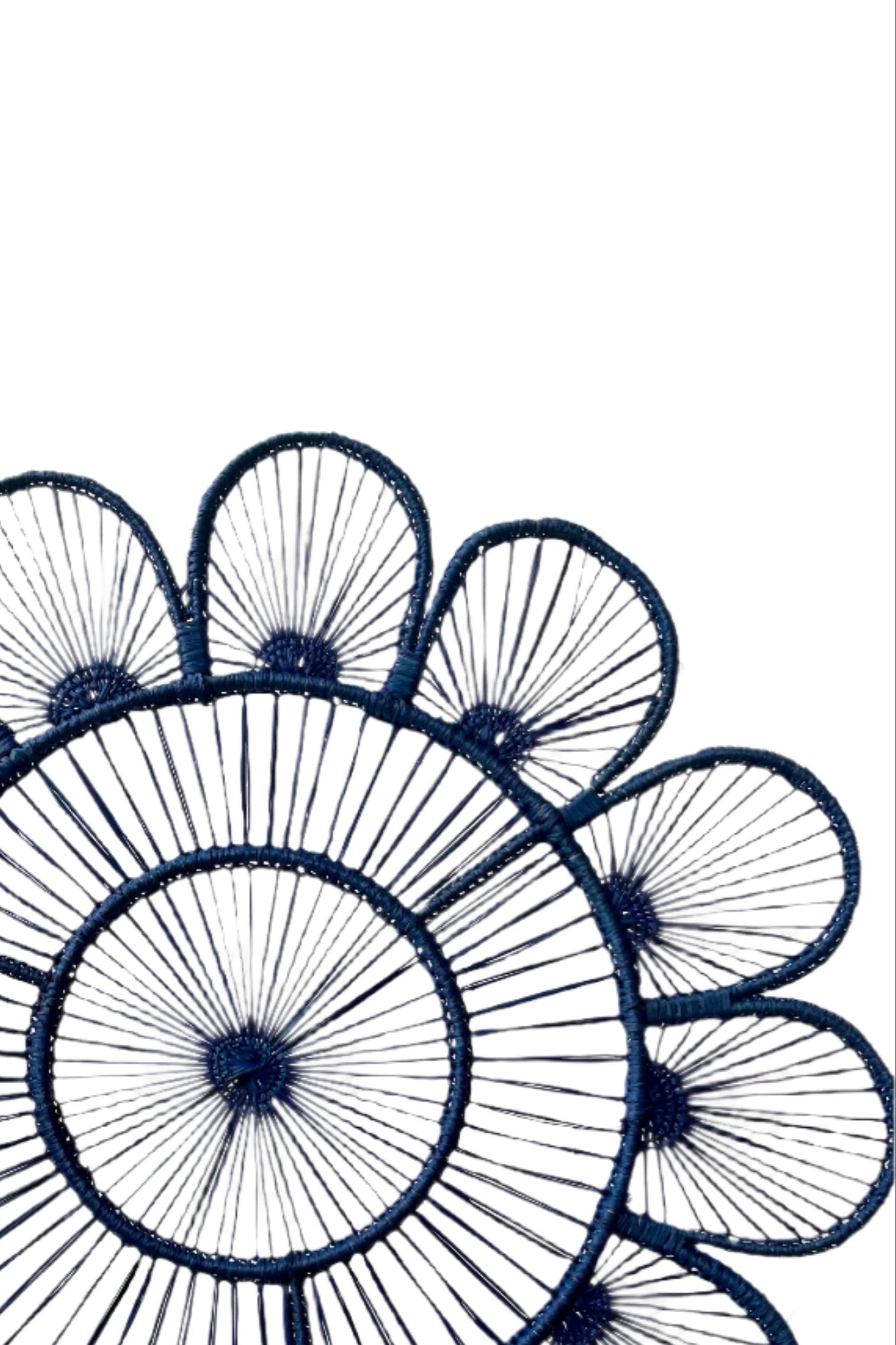 Close photo showing the weave of fiber around wire of a Lila Placemat Navy. Shown in front of a white background.