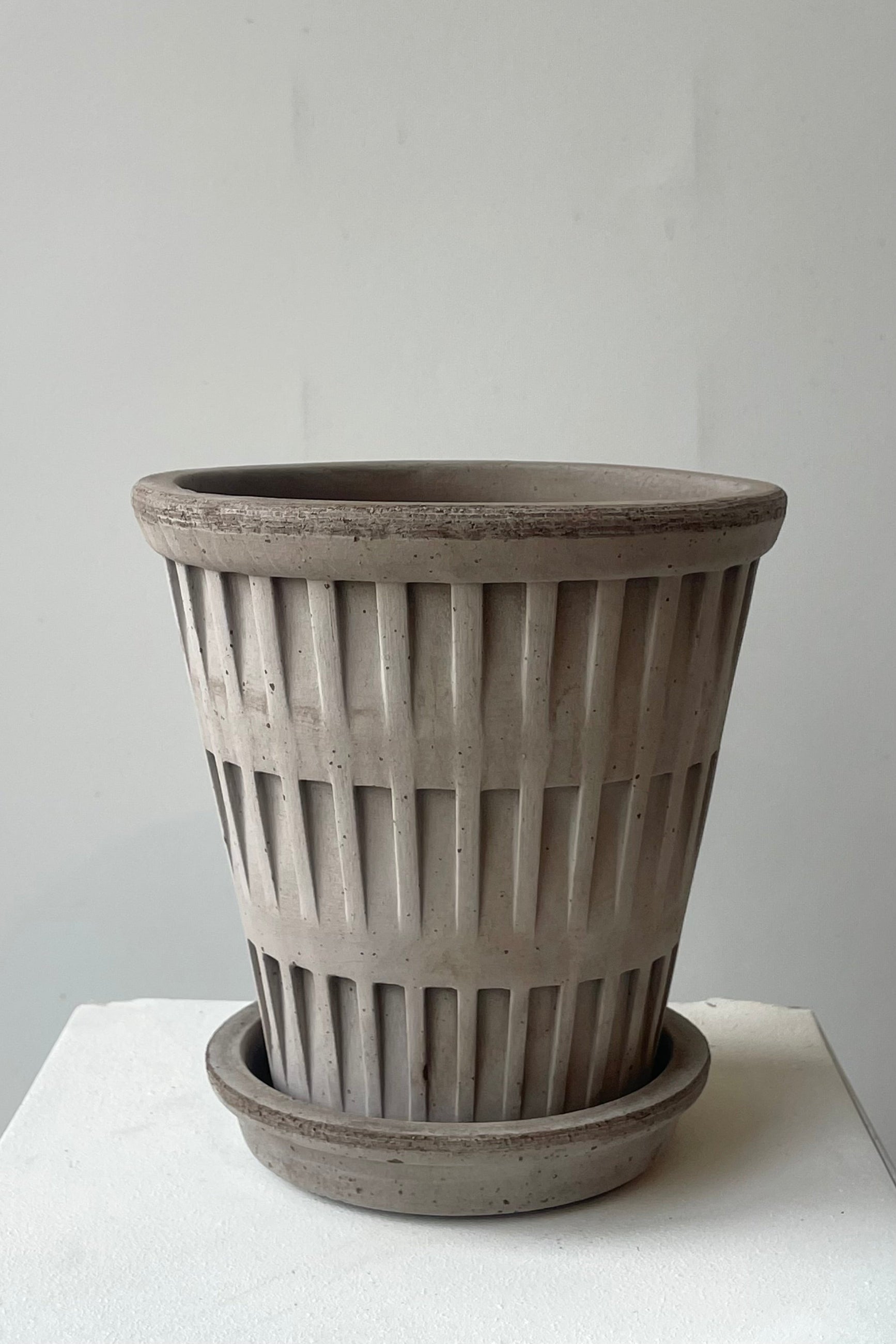 A gray pot and saucer in front of a white wall by Bergs Potter ©Sprout Home