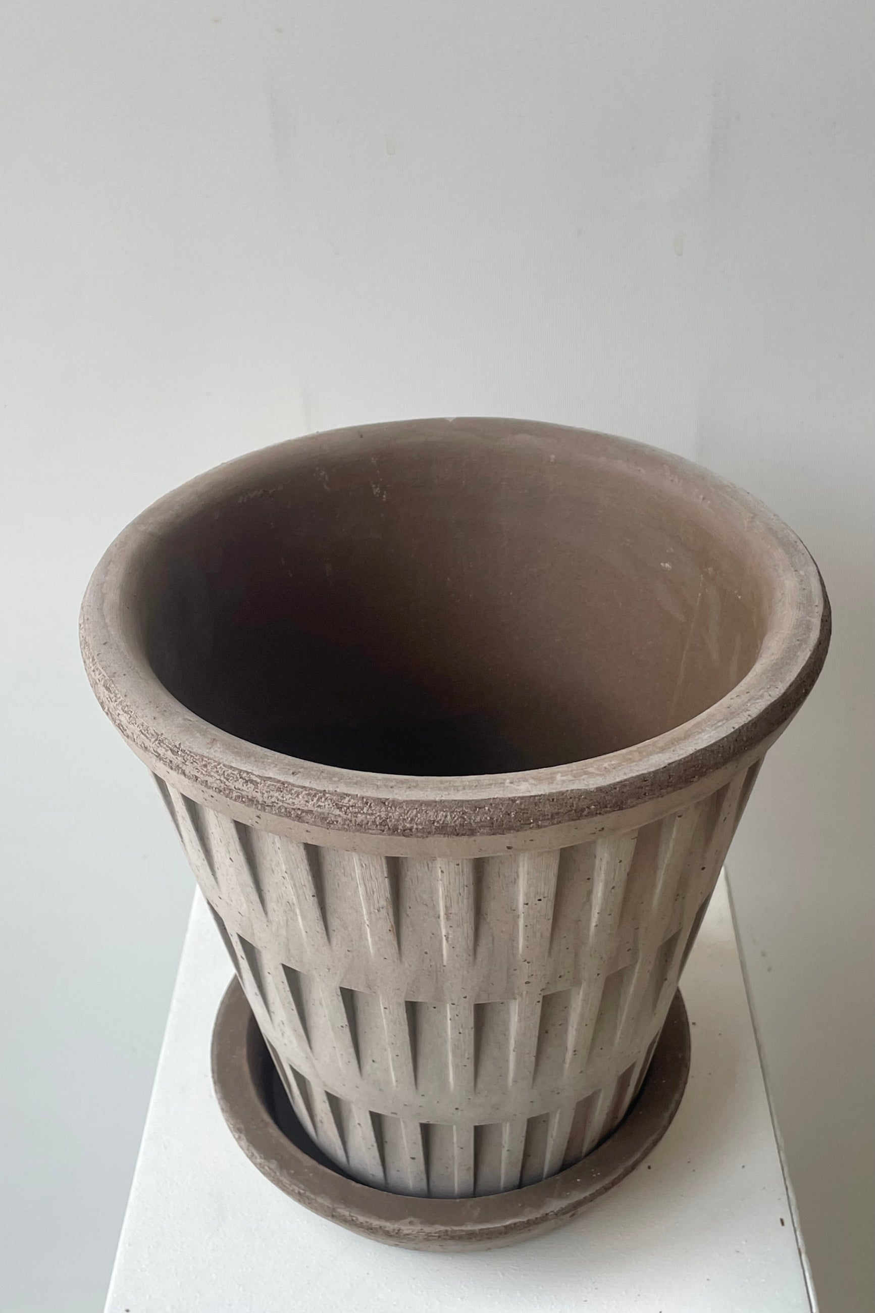A gray clay planter from above in front of a white wall ©Sprout Home