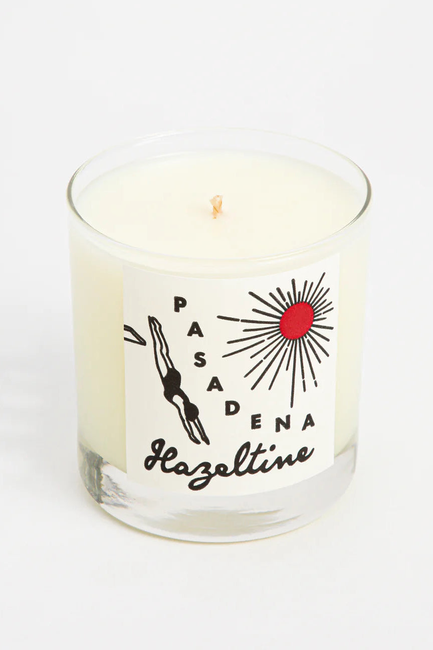 Candle in a glass jar with 'Pasadena Hazeltine' branding on a white background ©Hazeltine