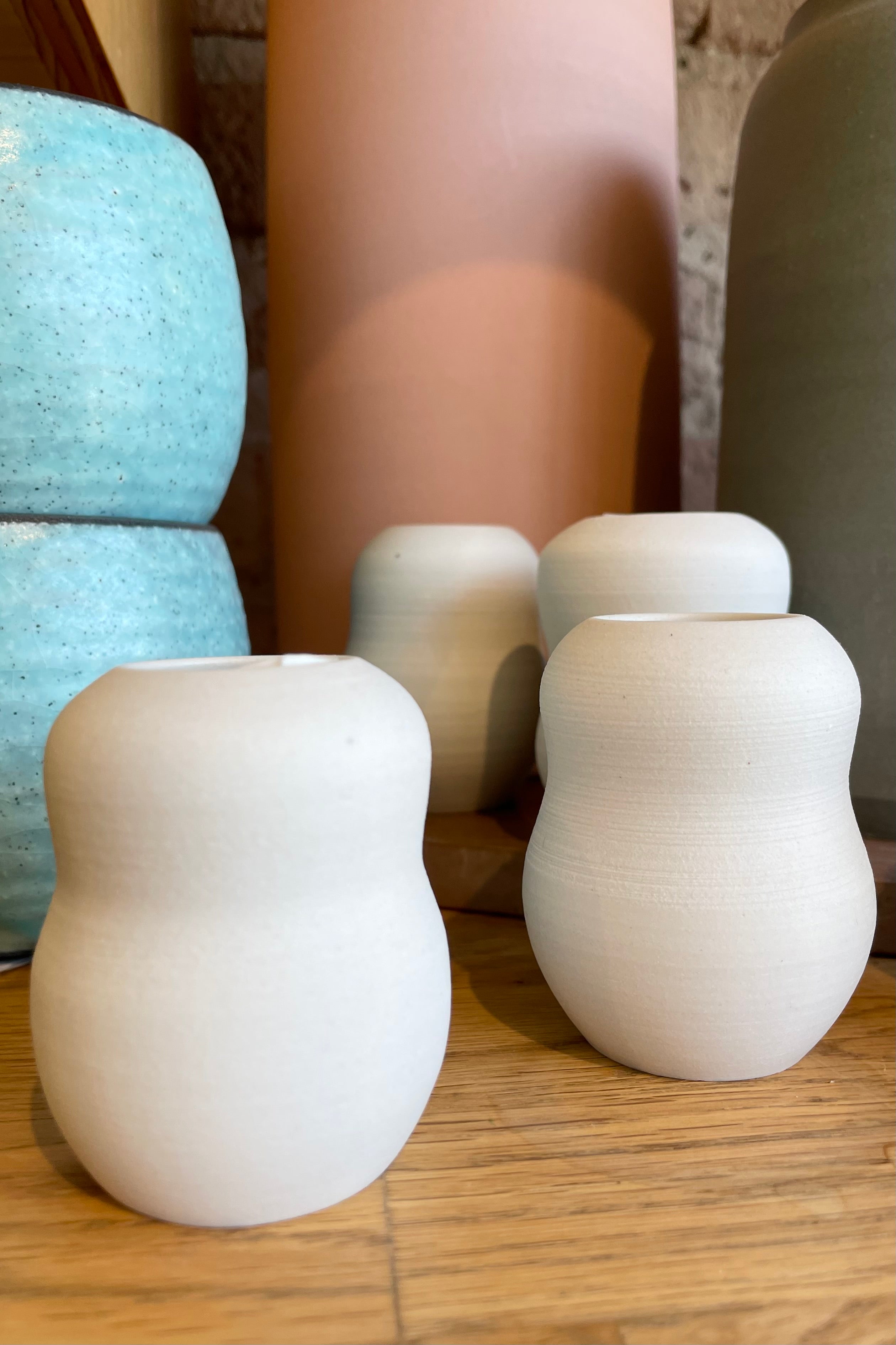 The petite pastel ceramic bubble vase in eggshell grouping with other vases in the background at Sprout Home floral & table store.