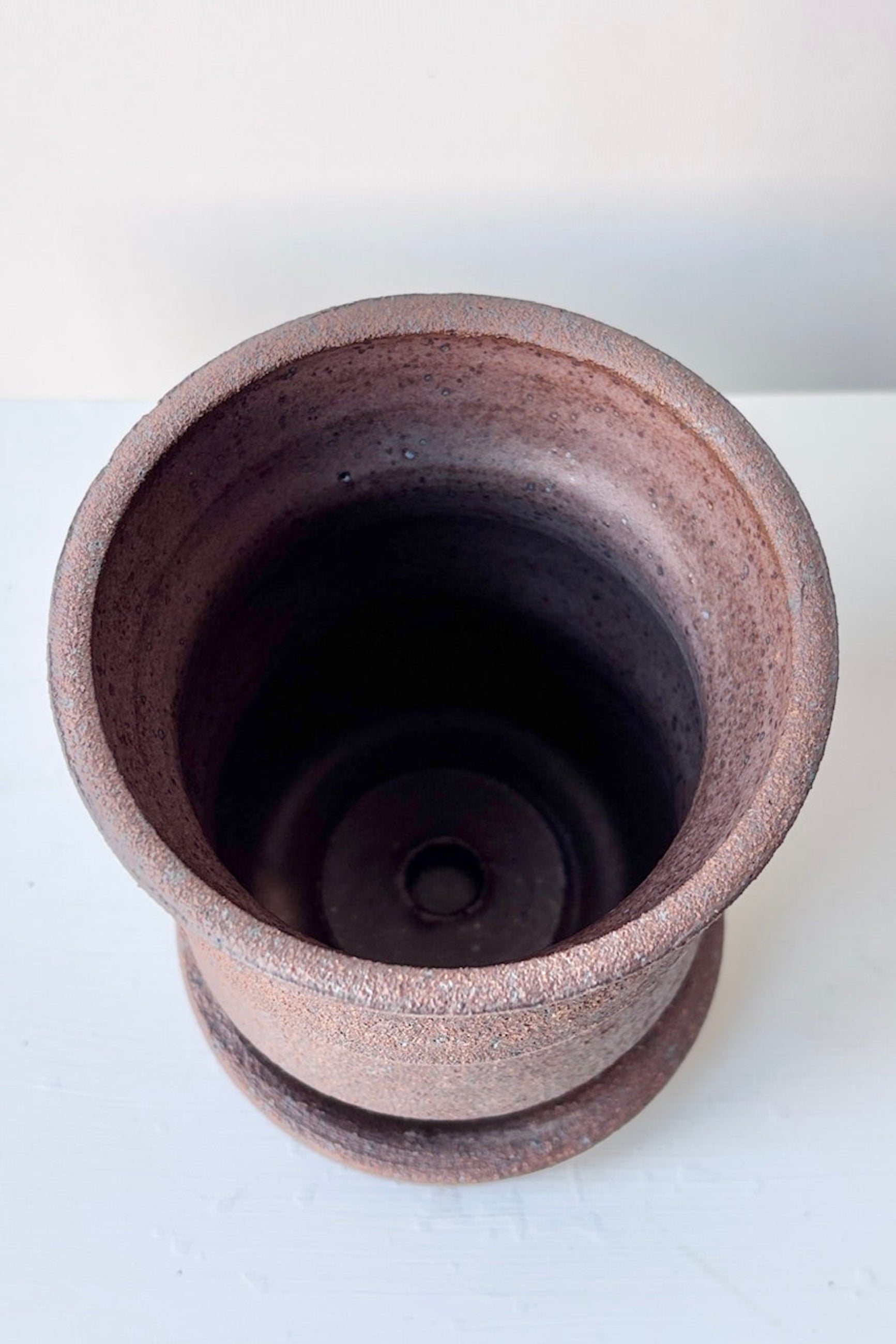 Overhead view of Olivia Snow Ceramics brown angled planter on a white table ©Sprout Home