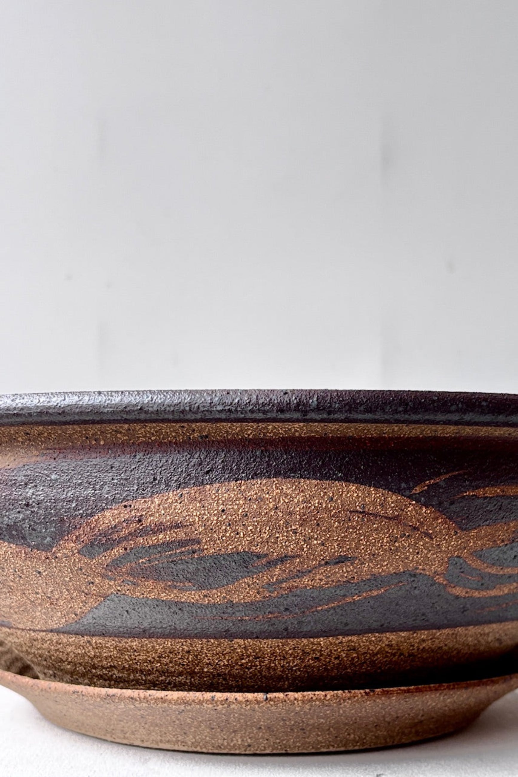 Detail of textured pattern on unglazed large low bowl against a white surface ©Sprout Home