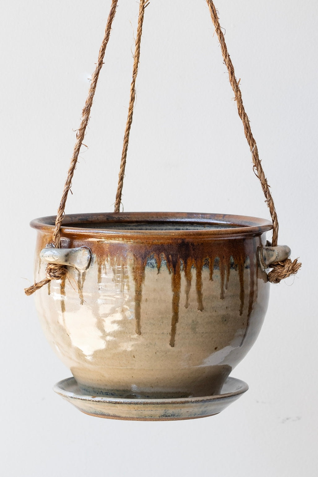 Detail of Bruning Pottery Hanging Planter ivory & iron glaze - 8" held in front of white wall ©Sprout Home