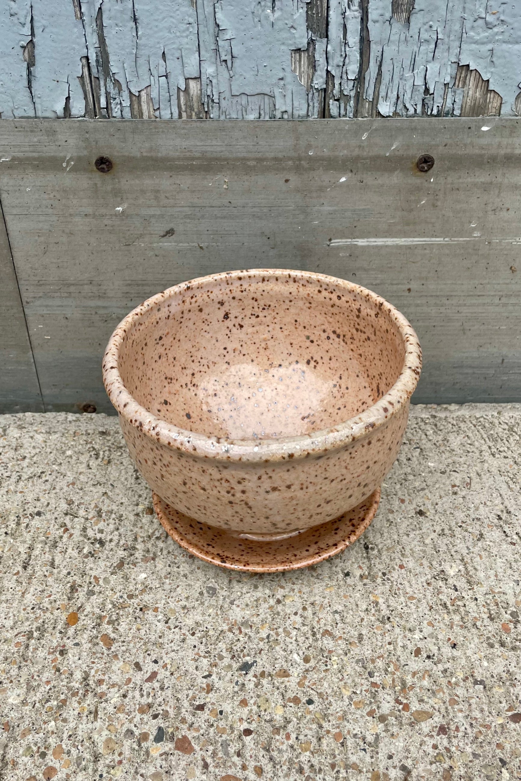 View looking down. A tan speckled planter in front of a wooden wall ©Sprout Home