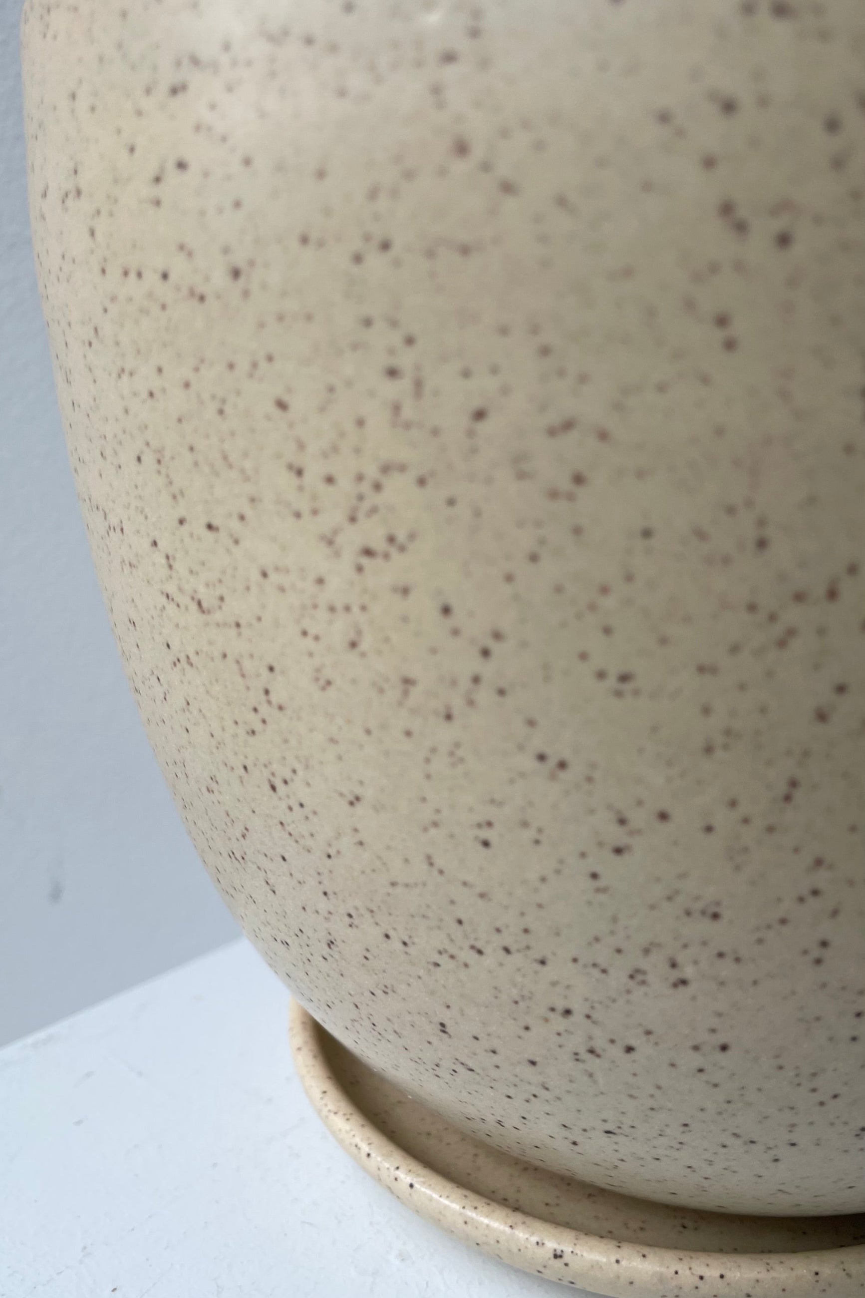 detail shot of the speckled butter glaze of the Tabletop planter and saucer. ©Sprout Home