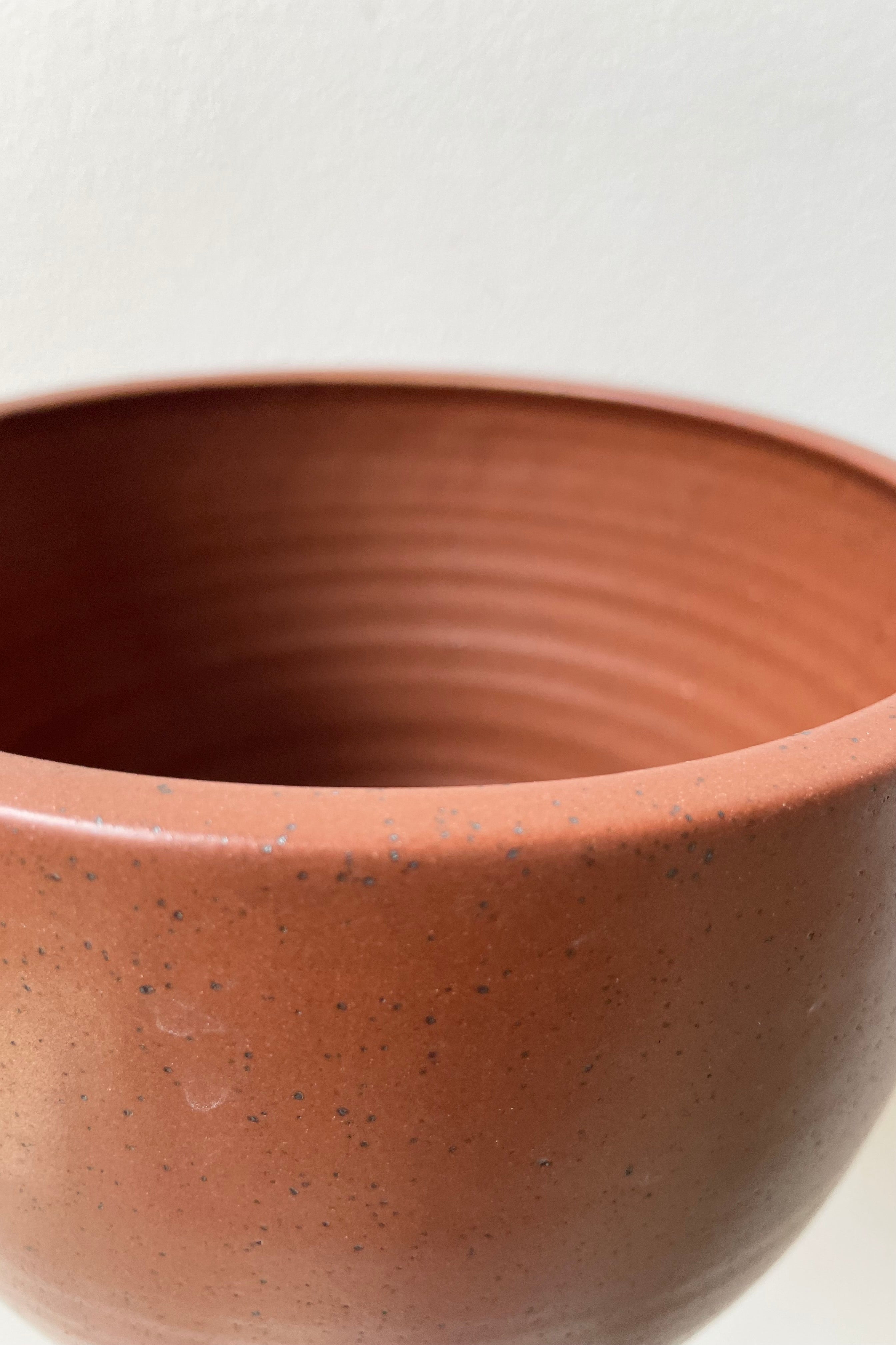 Detail of a tabletop planter in a chocolate speckle finish looking at the outside and inside.