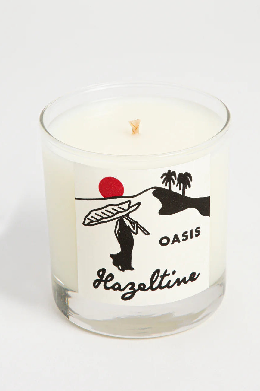 Candle with 'Oasis Hazeltine' branding on a white background©Hazeltine