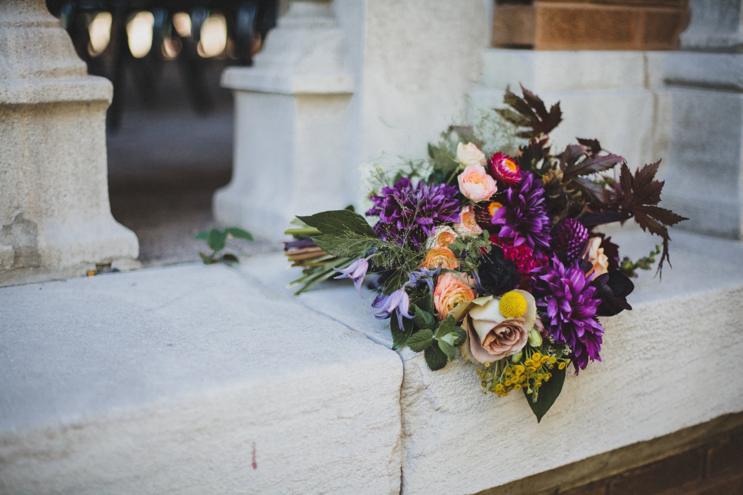 A dark purple primary color with peach and gray neutrals bouquet by Sprout Home. Photograph by Angela Renee Photography