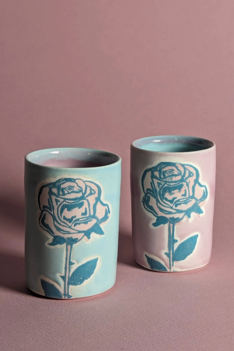 A pair of ceramic shot glasses each with a rose printed on the glaze ©City In Bloom Ceramics