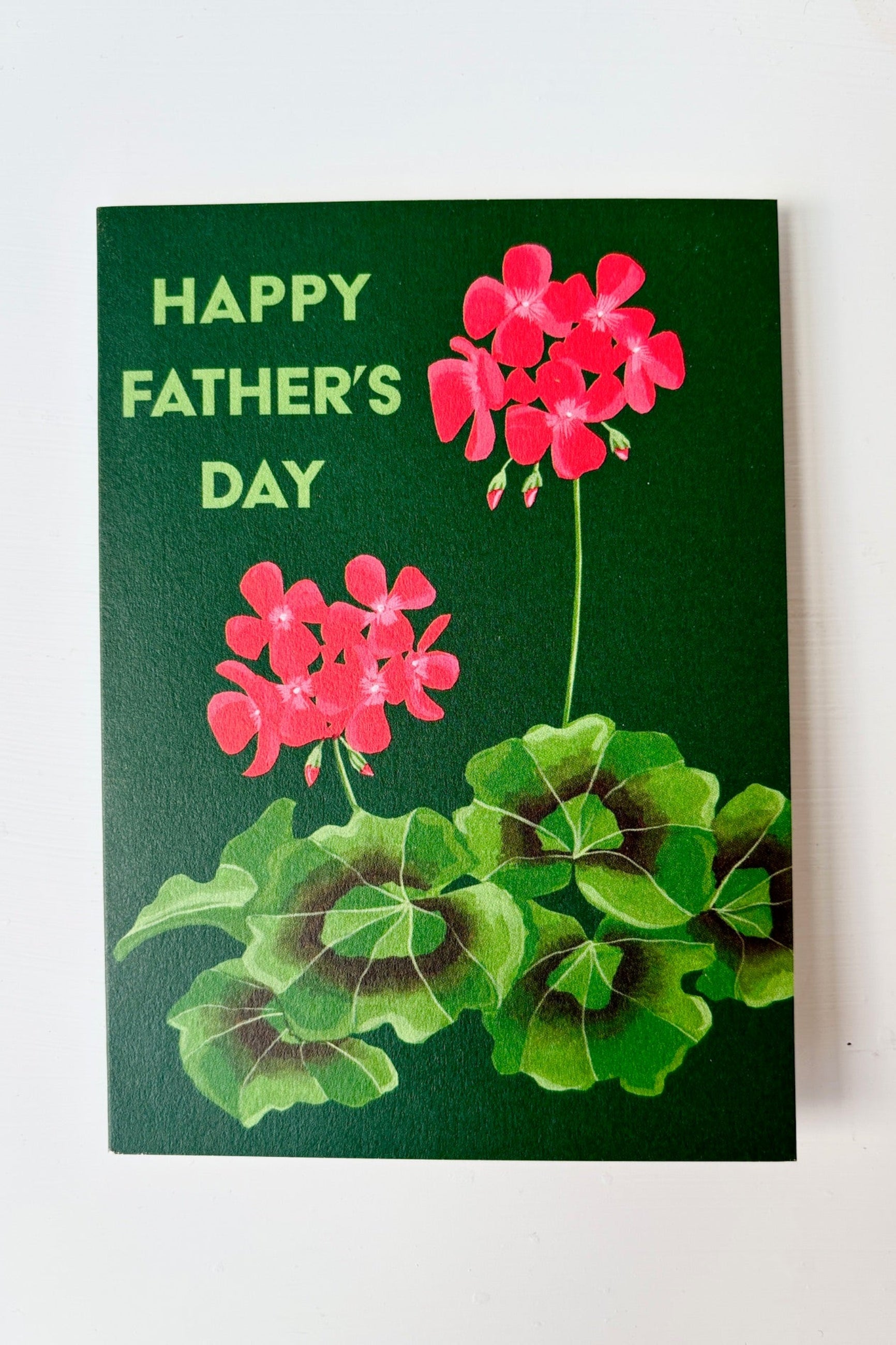Greeting card with image of red flowering zonal begonia with text that says Happy Father's Day on a green background ©Sprout Home
